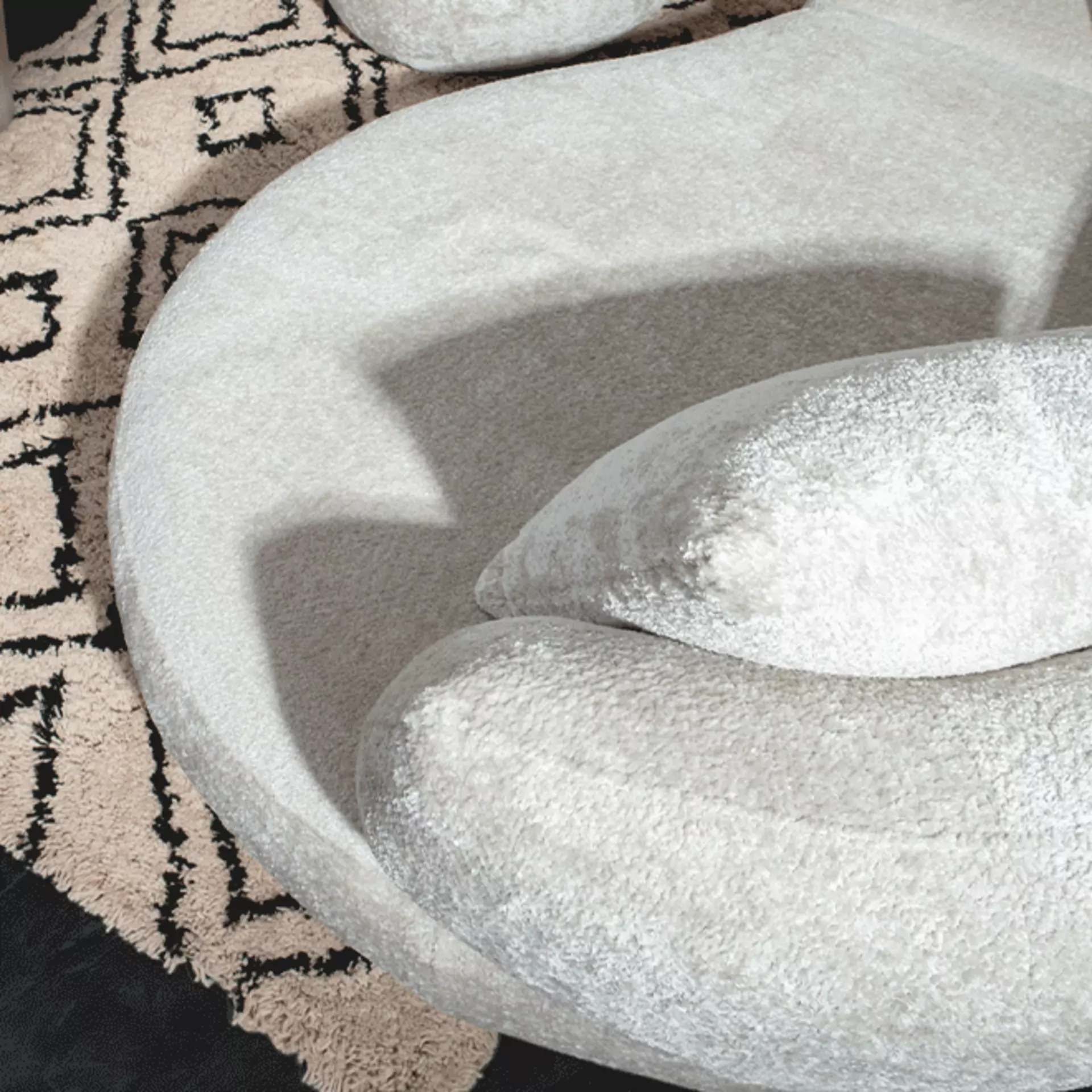 Nahaufnahme eines grauen Sofas mit weichem Bouclé-Stoff.