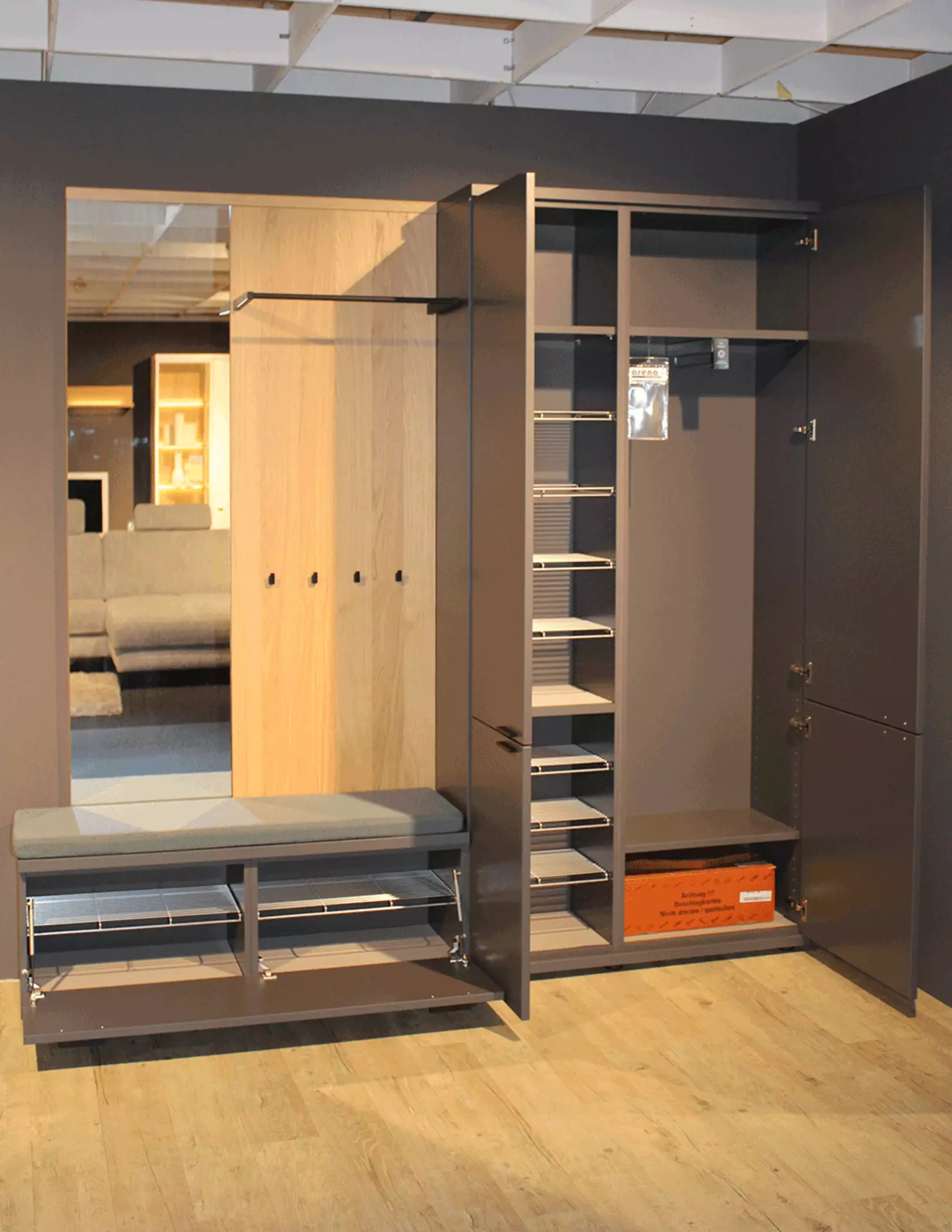 Dunkelgraue Garderobenkombination mit Kleiderschrank mit offenen Türen, Spiegel und Ablagefläche, in modernem, geradlinigem Design, vor neutralem Hintergrund