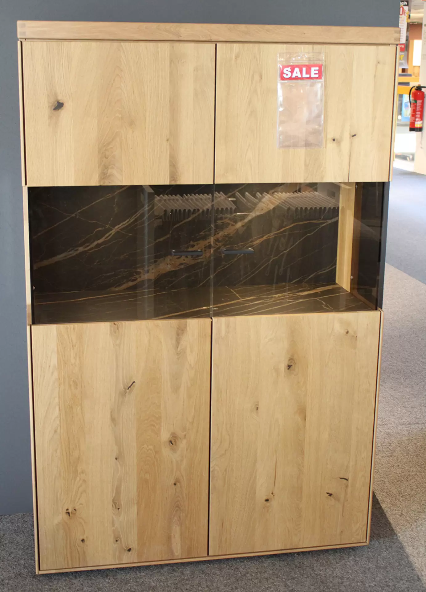 Das Highboard TIRANO von Wöstmann aus massivem Holz miz Glaselementen