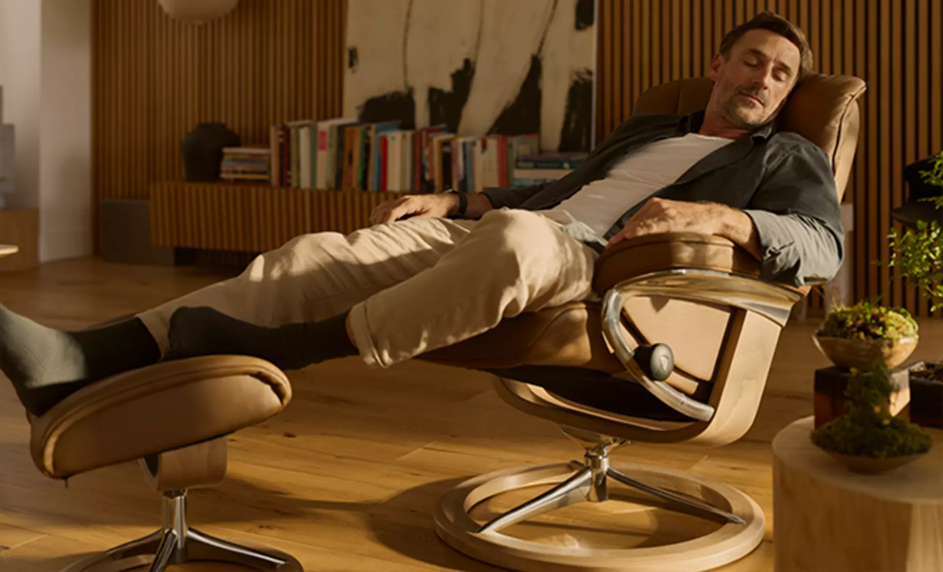 Ein Mann entspannt im Stressless Mayfair Sessel in Velaro Caramel gepolstert
