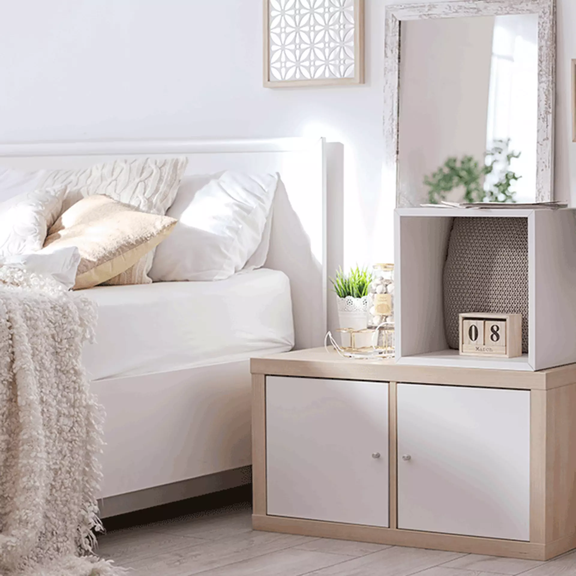 ein Schlafzimmer mit beiger und weißer Bettwäsche, Kissen und Deko.