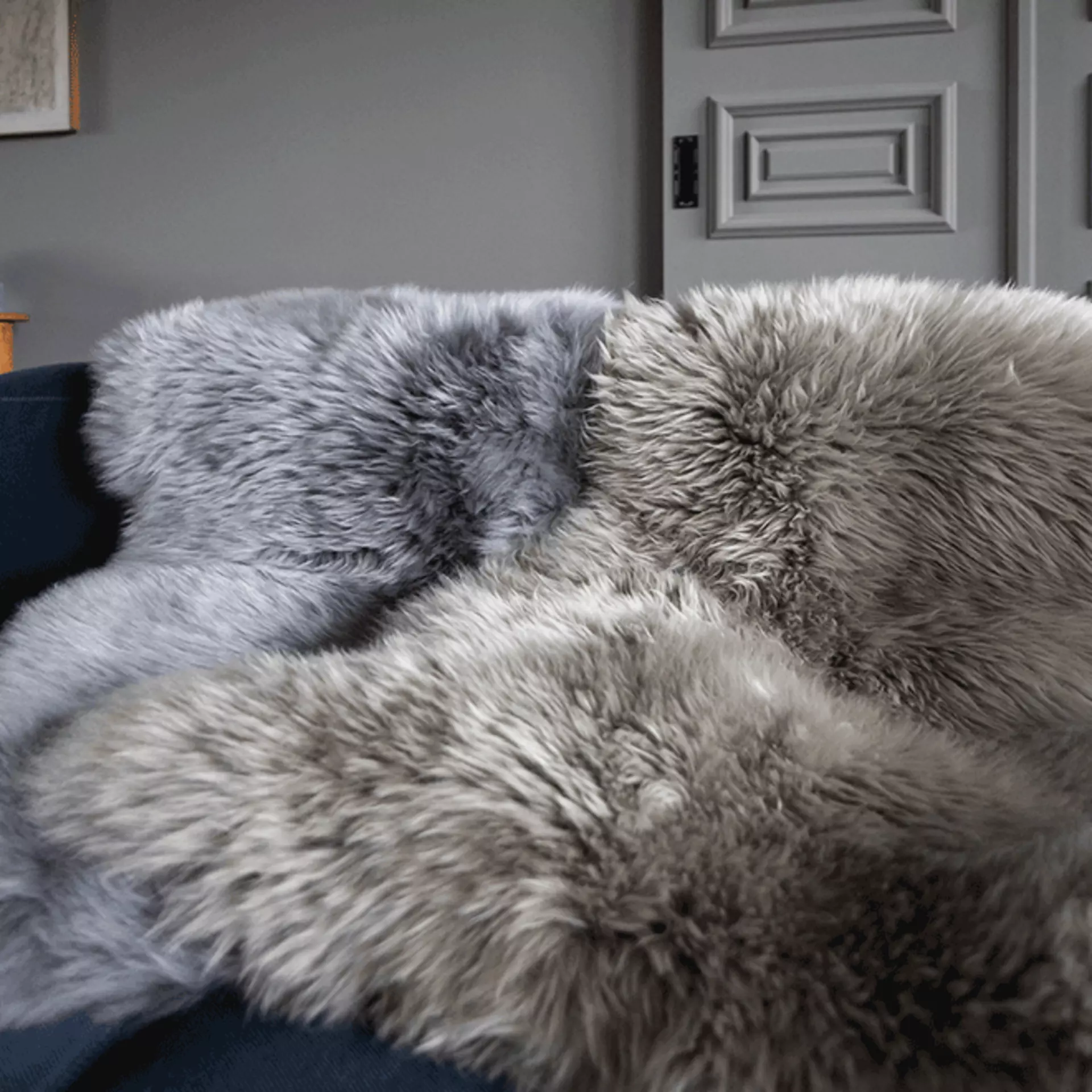 Decke aus grauem Fell auf einem SOfa