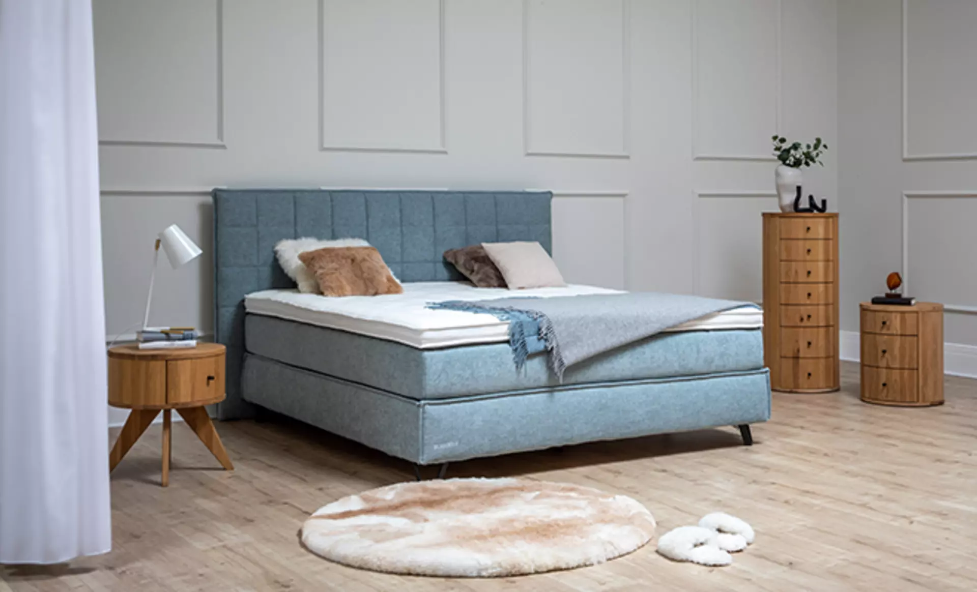 das Sjöholm Pura Boxspringbett in Aquamarin Stoffbezug in einem modernen Schlafbereich