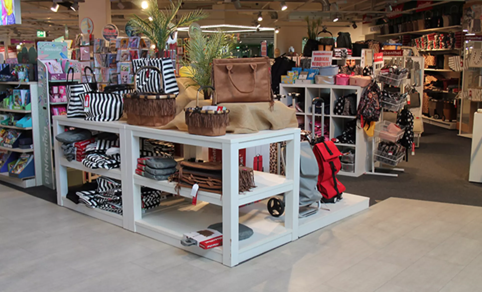 Shopper von der Marke Reisenthel in verschiedenen Farben die auf einer Verkaufsfläche liegen