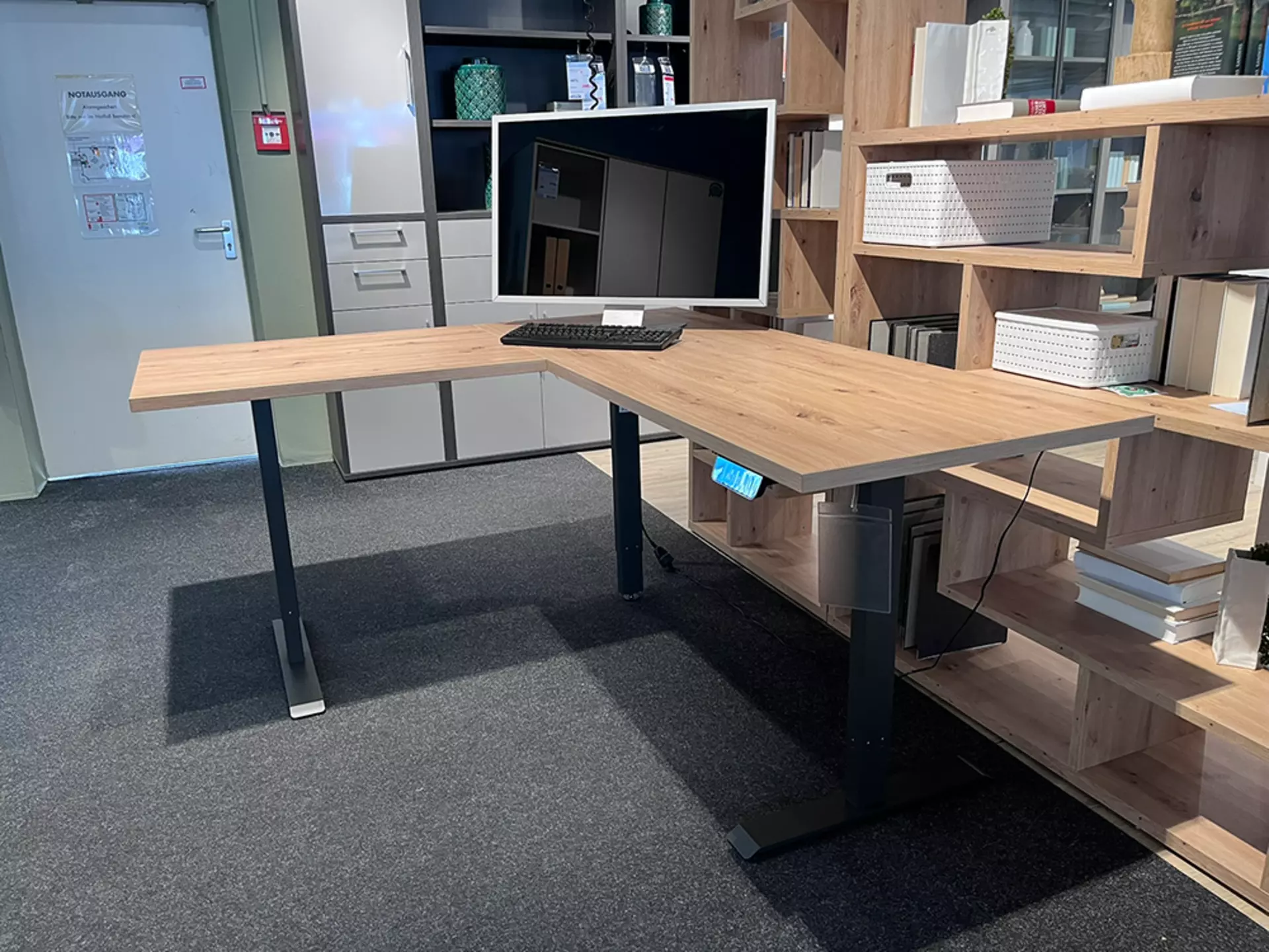 Ecktisch aus Holz das mit Schwarzen metallbeinen ausgestatet ist und höhenverstellbar ist 