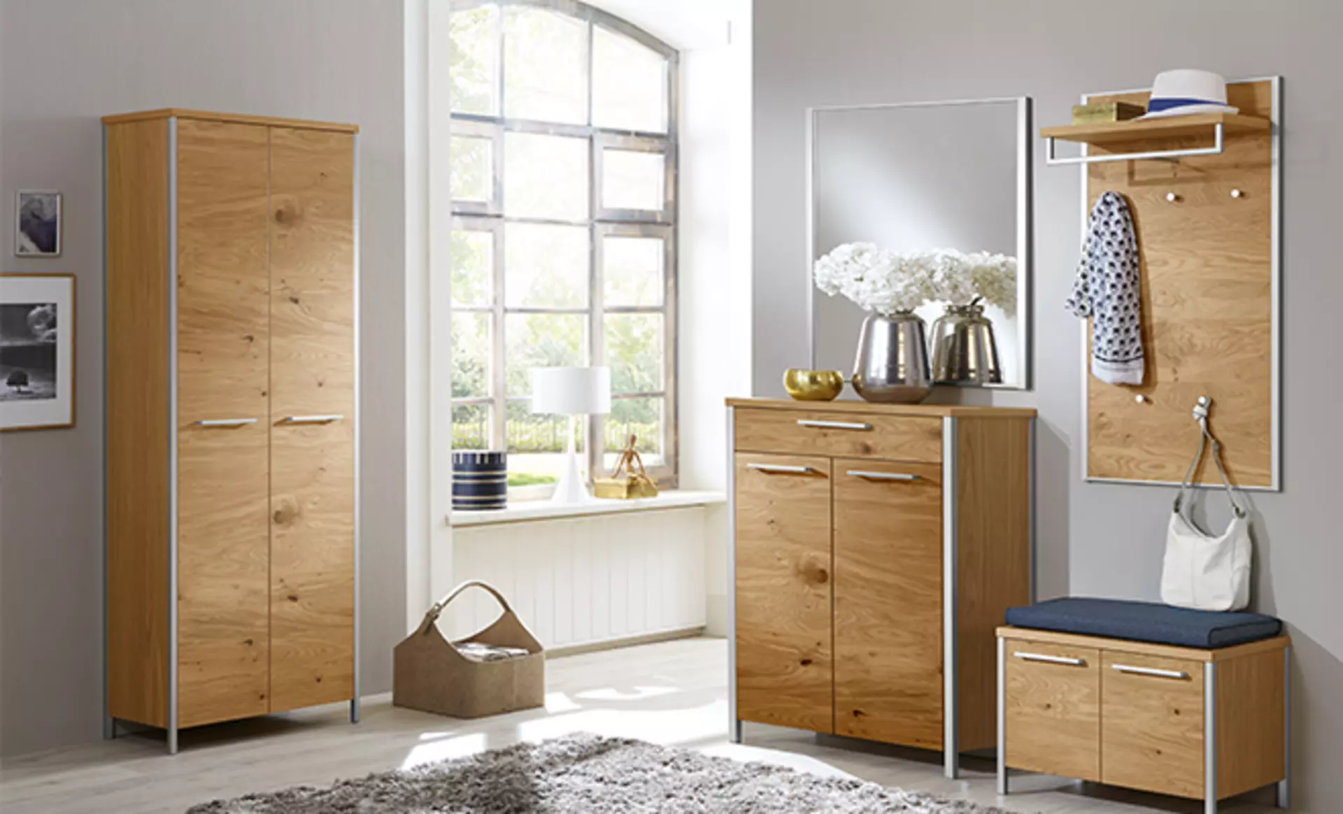 Garderobe aus Hellem Holz die neben einem Großen Fenster steht und Belichtung abbekommt