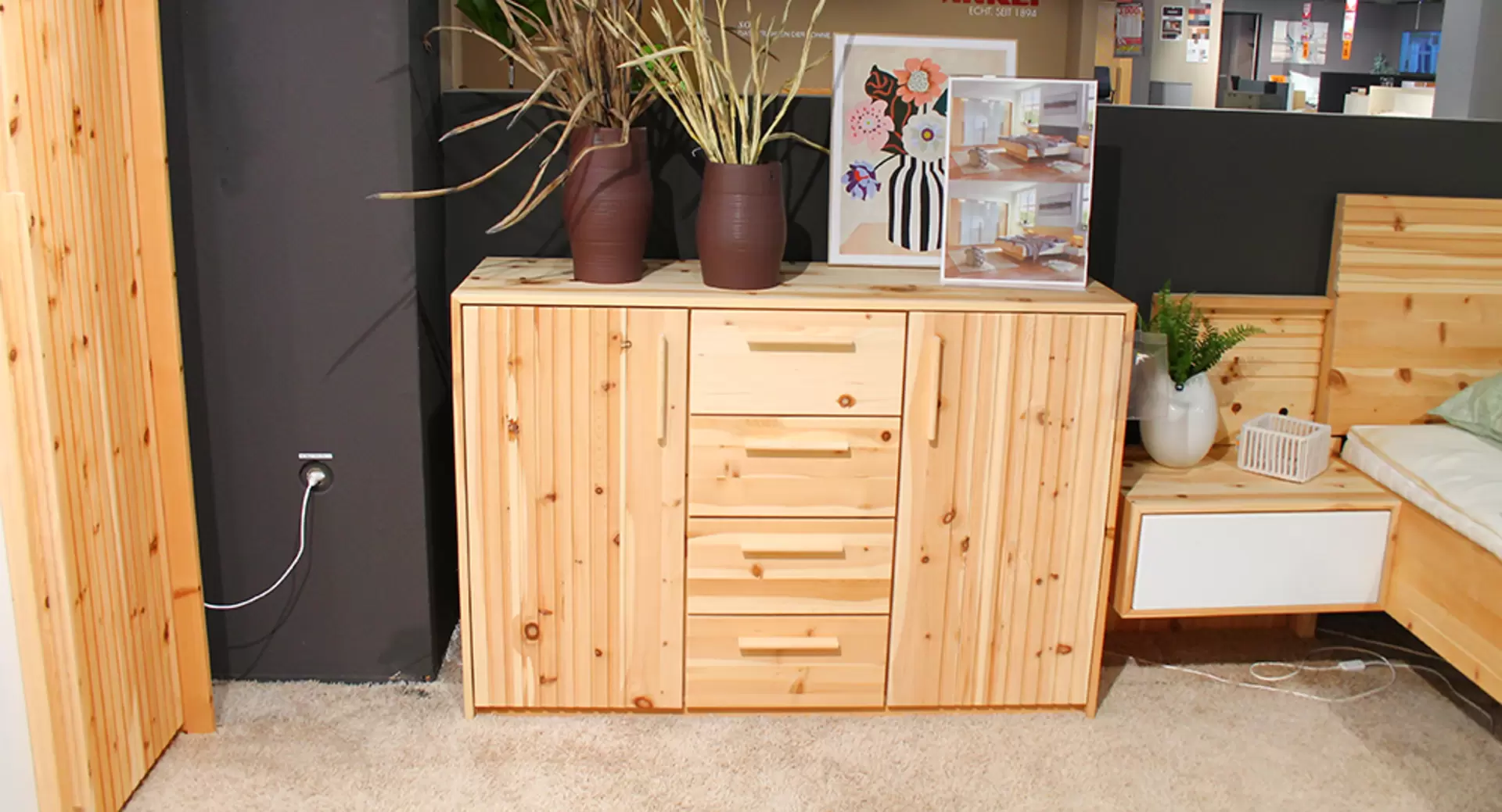 Ein Schlafzimmer von Lip Phistvo aus zirbe massiv mit Bett, Kommode und Schrank mit weißen Lackelementen