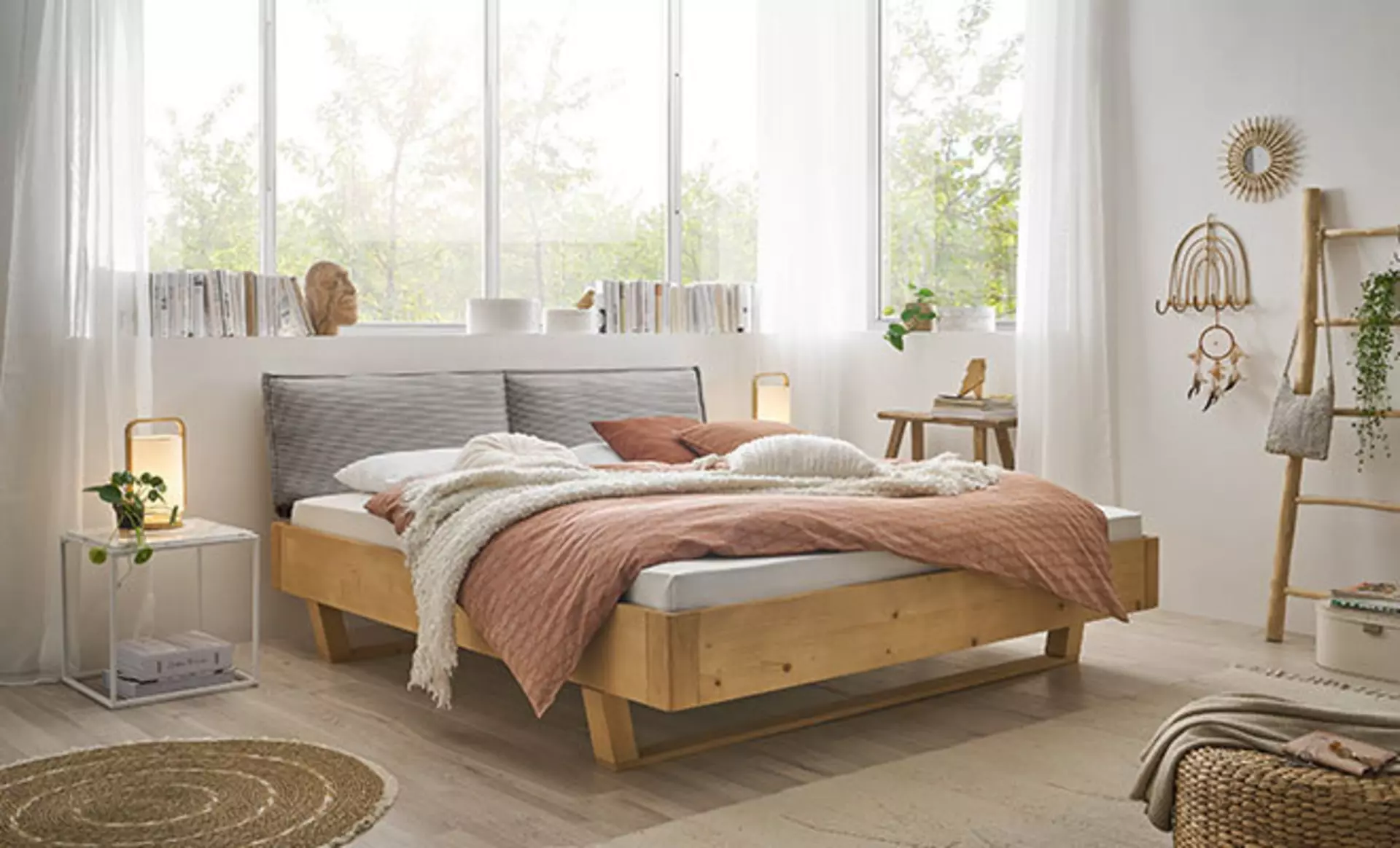 Ein Schlafzimmr mit einem gemütlichem Bett aus Massivholz