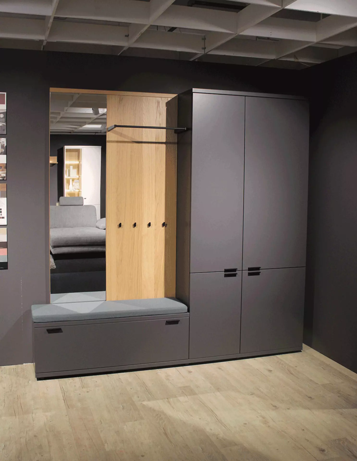 Dunkelgraue Garderobenkombination mit Kleiderschrank, Spiegel und Ablagefläche, in modernem, geradlinigem Design, vor neutralem Hintergrund