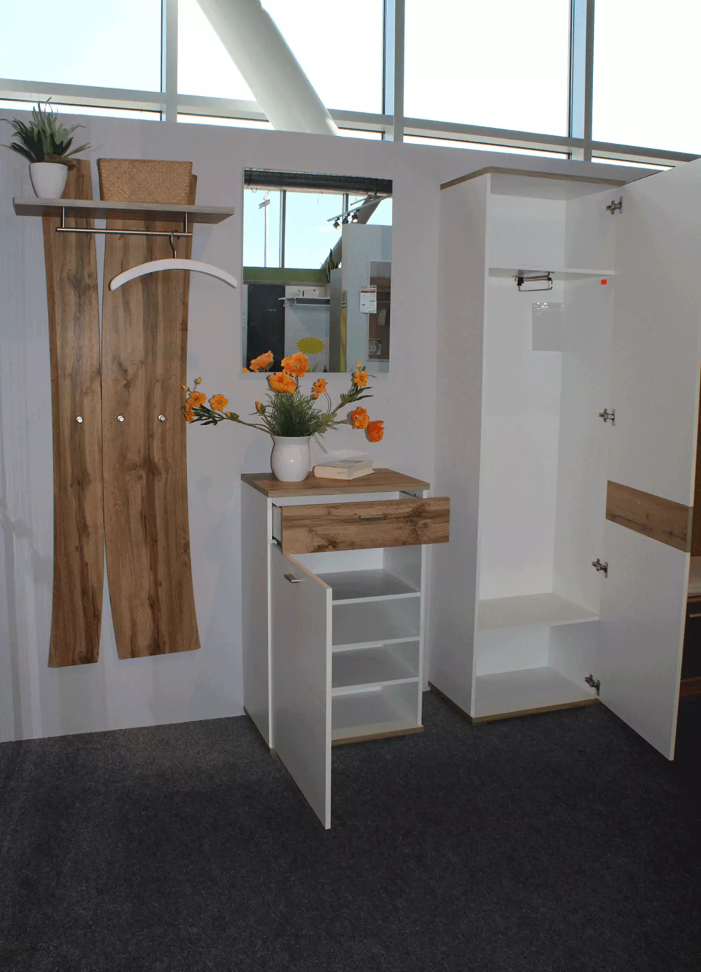 Weiße Garderobe mit Holz-Akzenten und geöffneten Türen