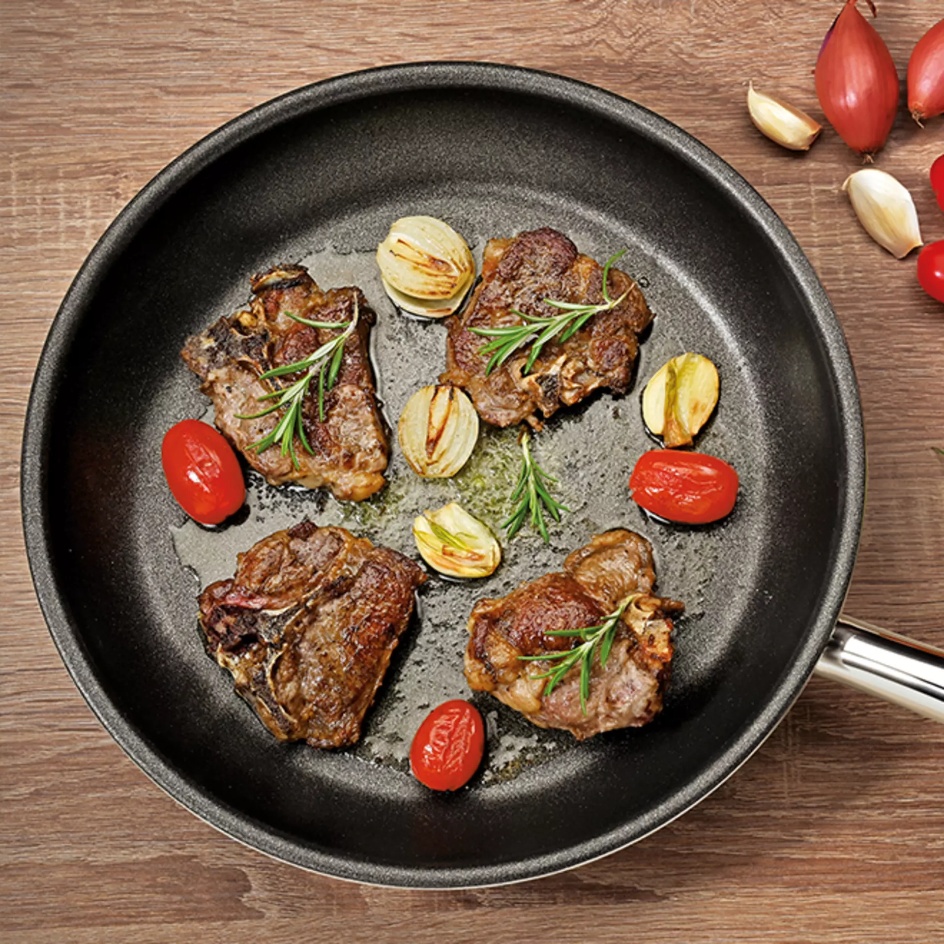 Steaks mit Rosmarin und Knoblauch angebraten in einer Bratpfanne von der Marke Spring