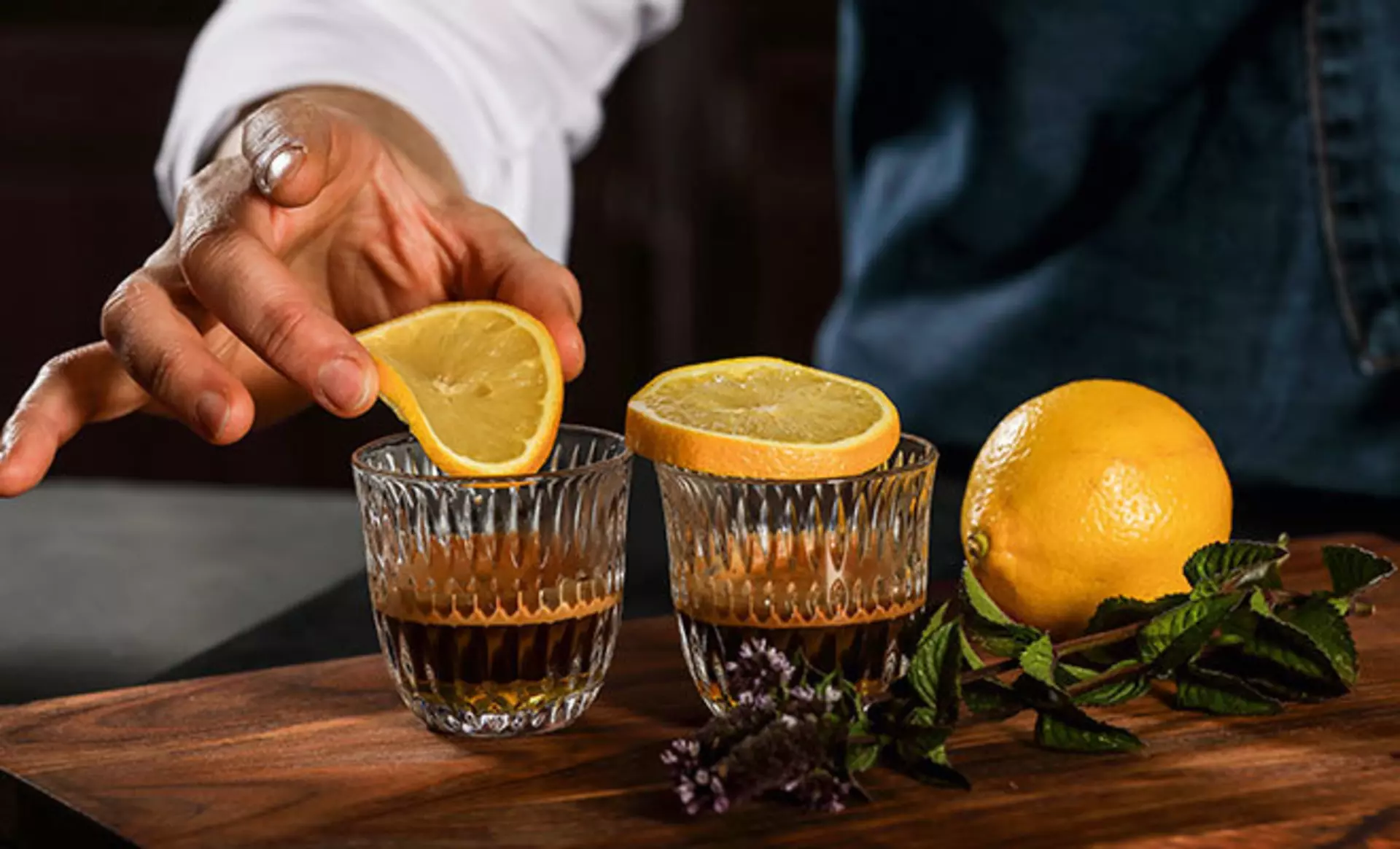 Ein Koch welcher Zitronen in ein Nachtmann Glas presst