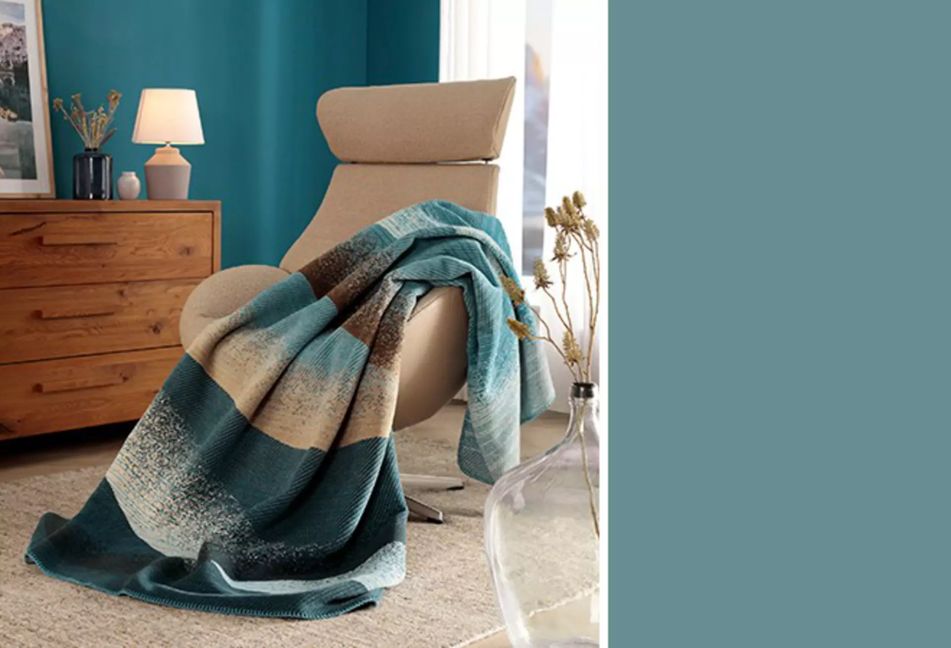 Blaues Wohnzimmer mit einer mehrfarbigen blauen Decke auf dem Sofa.