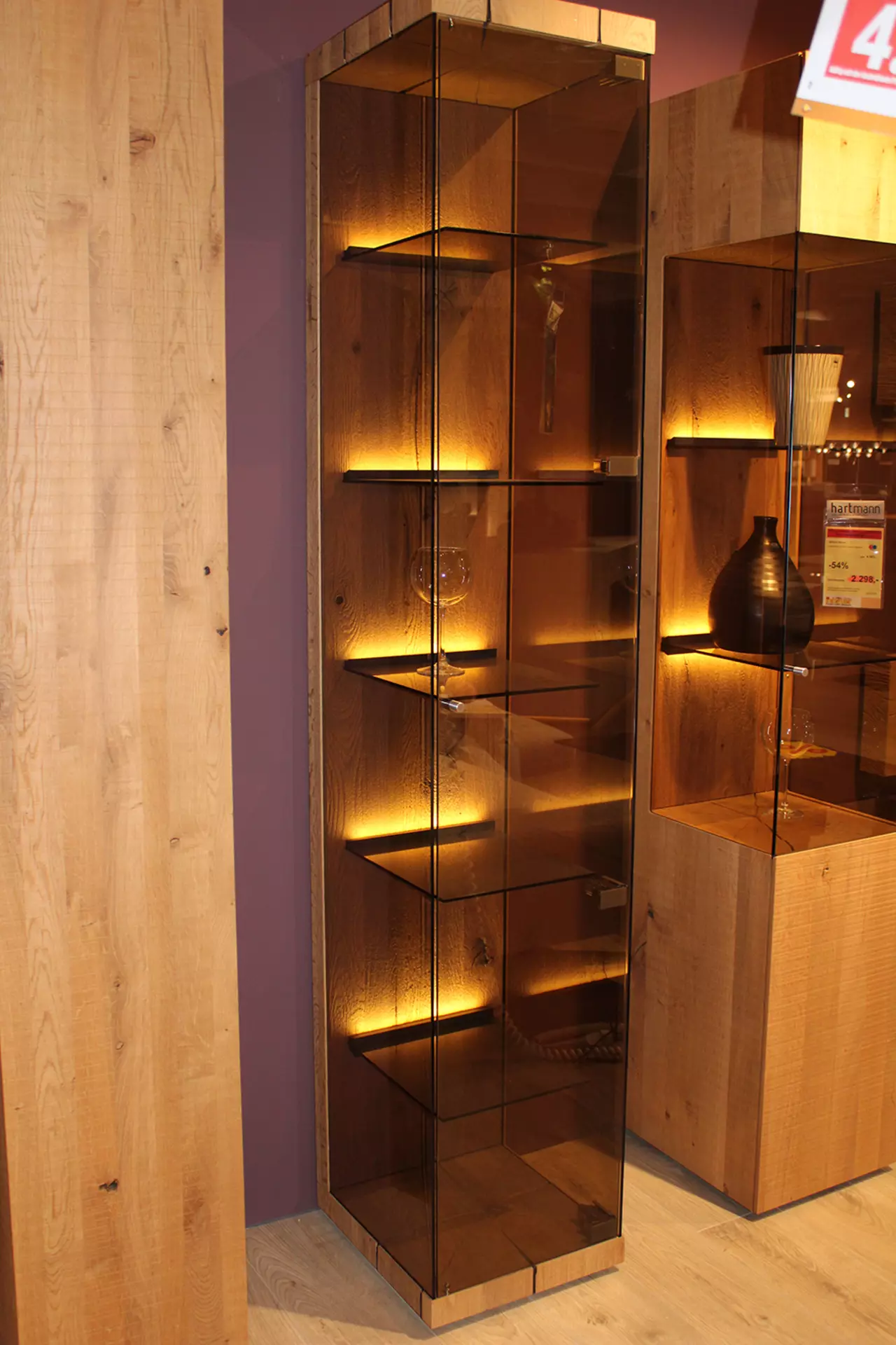 Vitrine mit Rauchglasfront und Holzoptik mit warmer indirekter bleuchtung