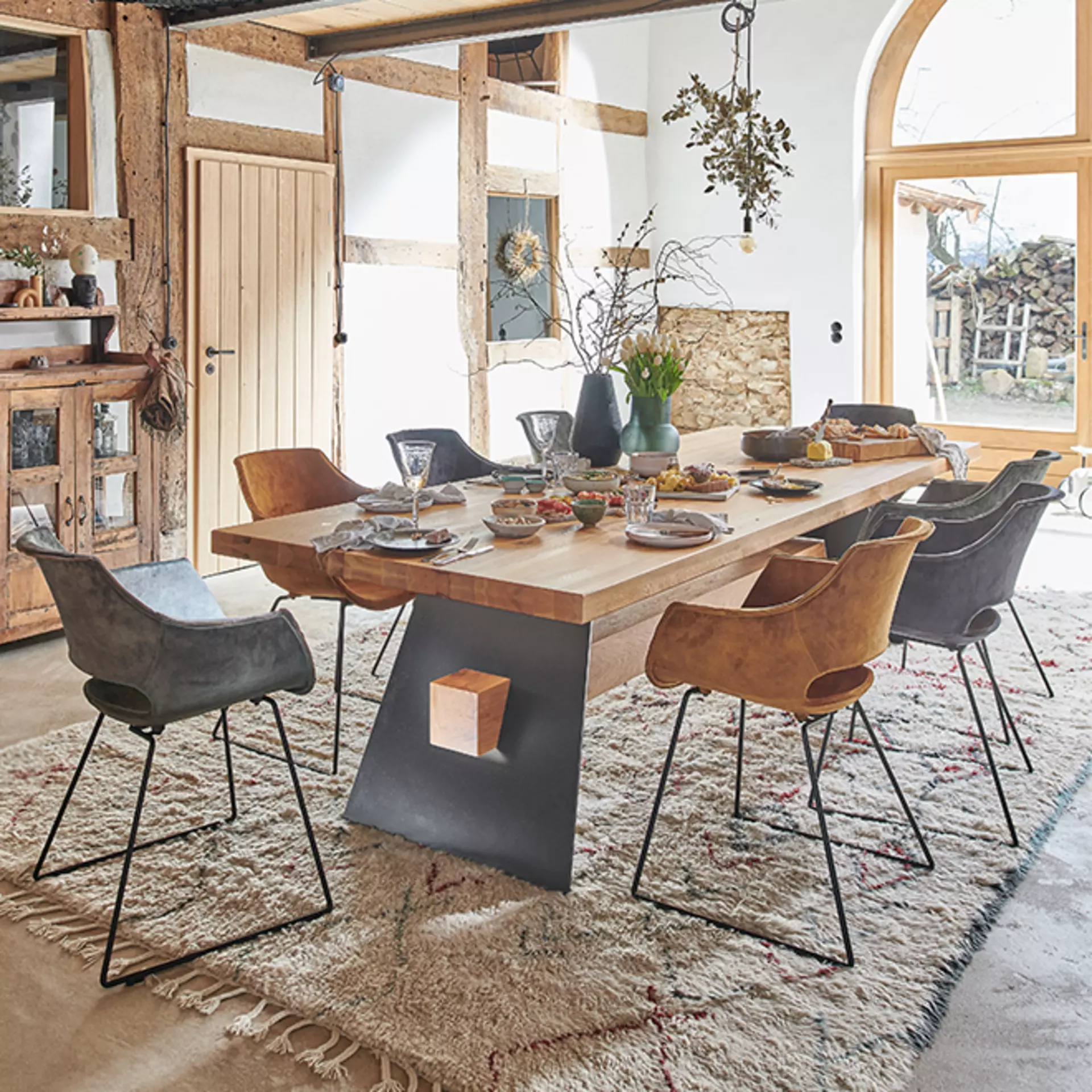 Ein Bodahl Esstisch aus dunklerem Holz mit Metall-Holz Gestell und passenden Stühlen in Grau und Ocker gepolstert