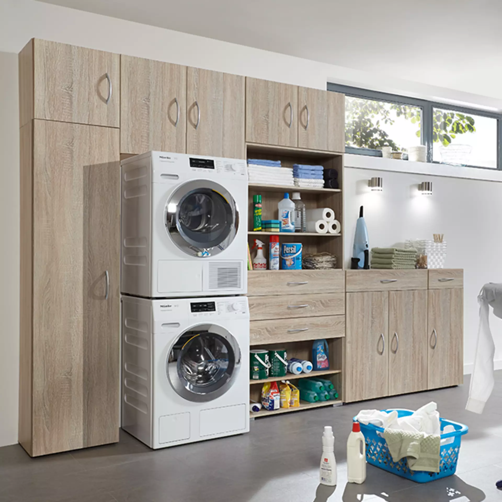 Waschküche mit Holzschränken, Waschmaschine, Trockner und Stauraum.