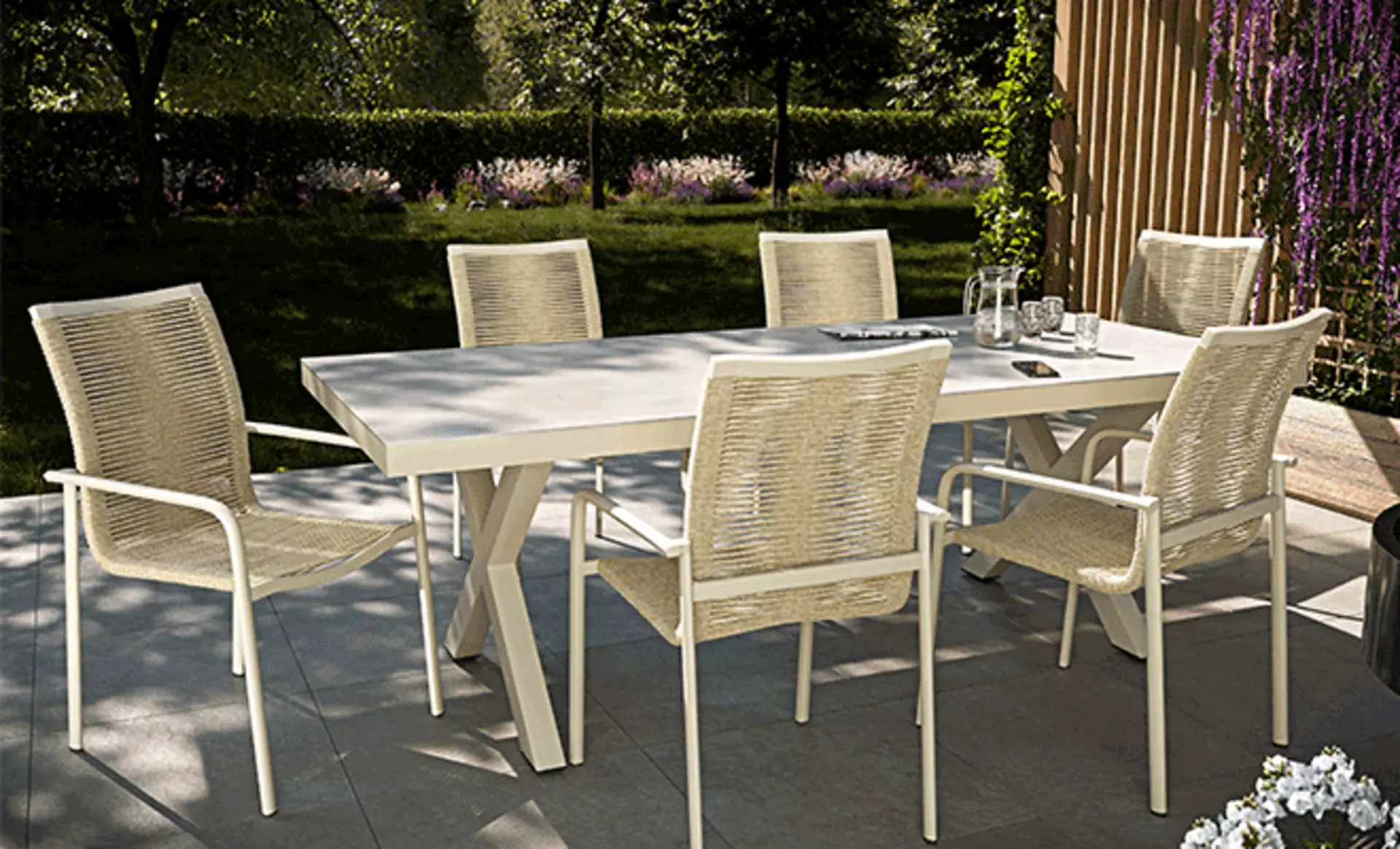 Ein Esstisch in Weiß der draußen auf der Terrasse steht 