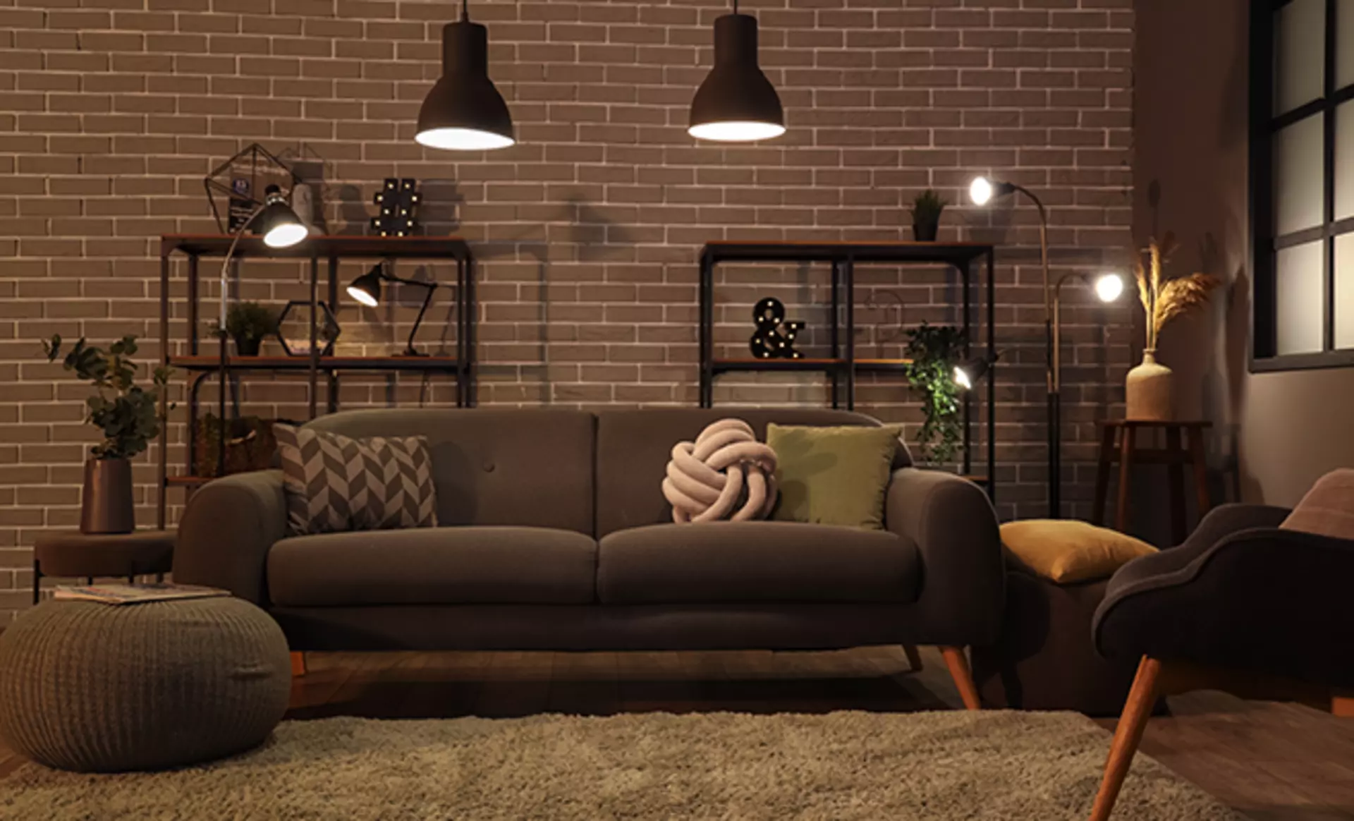 Loft-Wohnzimmer im Industrial-Look mit gut platzierten Stehleuchten und dekorativen Kissen auf zweieinhalbsitzer Couch