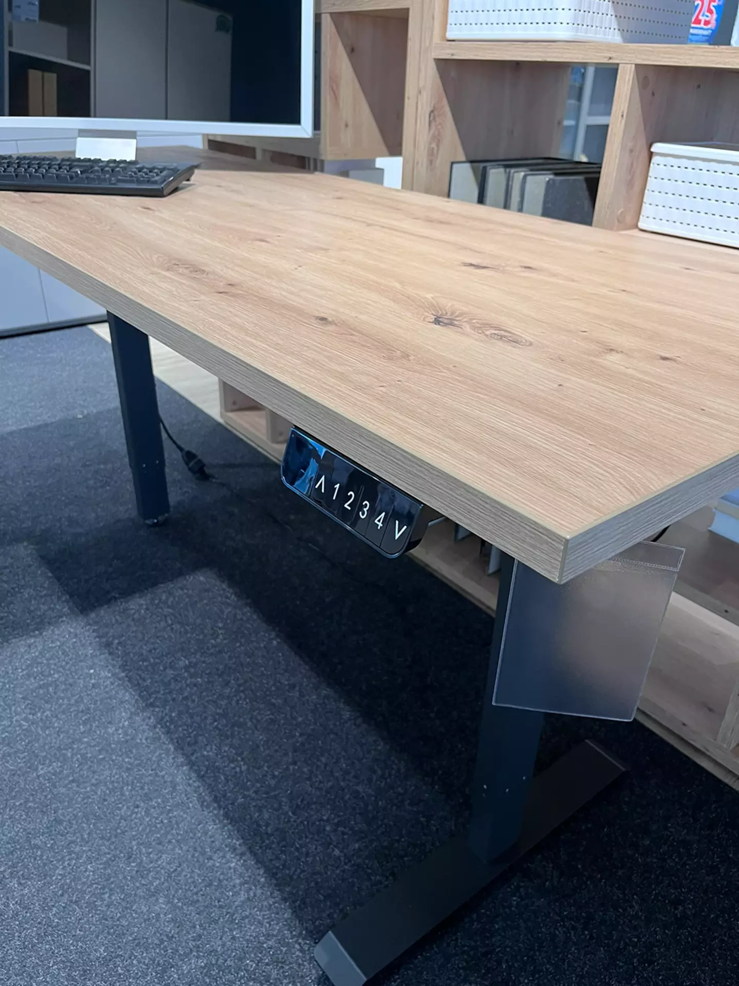 Schreibtisch bei dem ein Nummernfeld angebracht ist auf dem man die Tischhöhe variieren kann