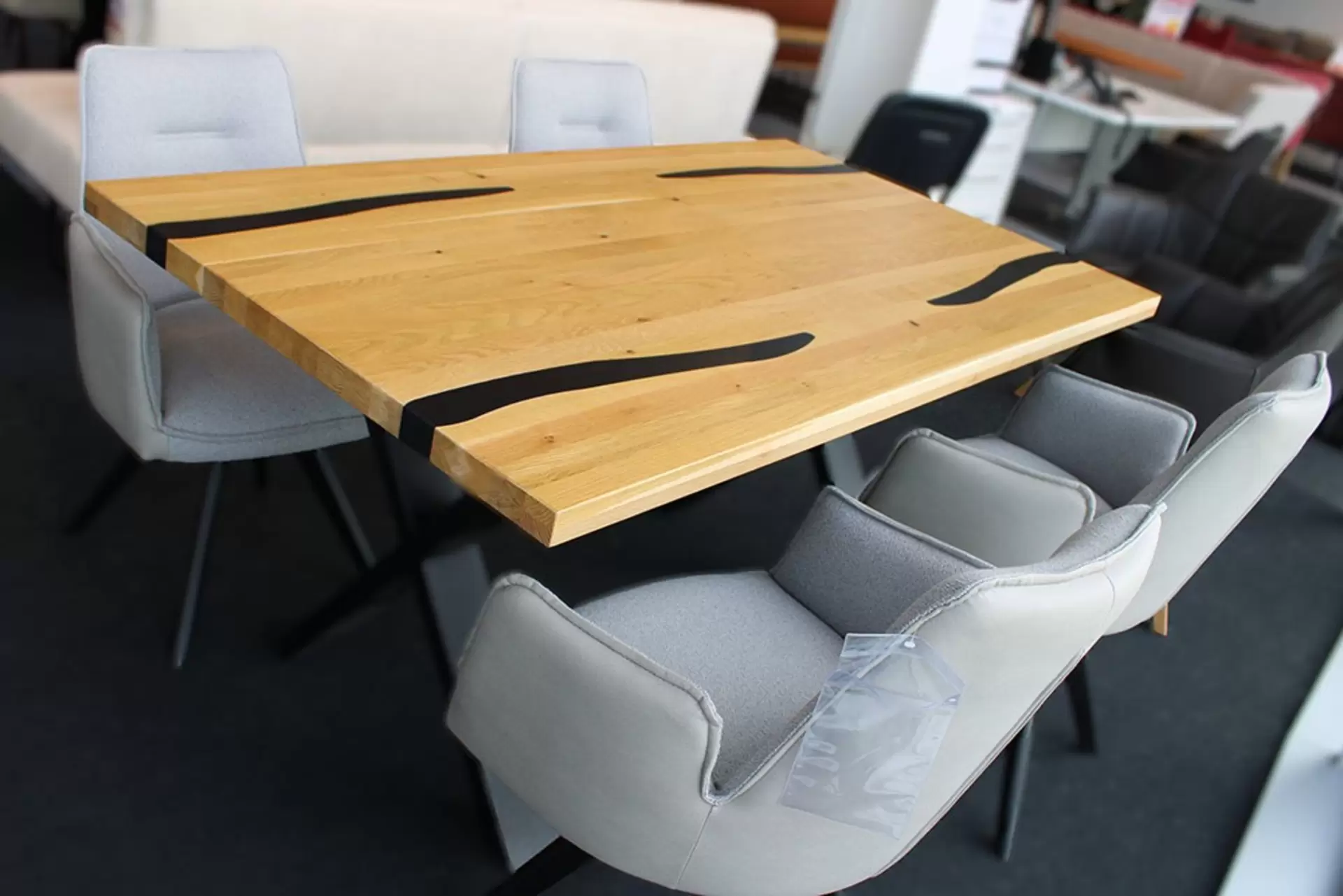 Tischgruppe mit Holztisch mit schwarzen Details und graue Stoffstühle