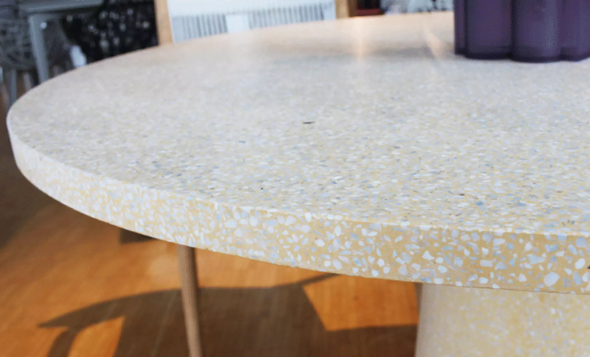 Der DineOut Tisch von Cassina im Detail: die runde Steintischplatte in heller Terrazzo-Optik