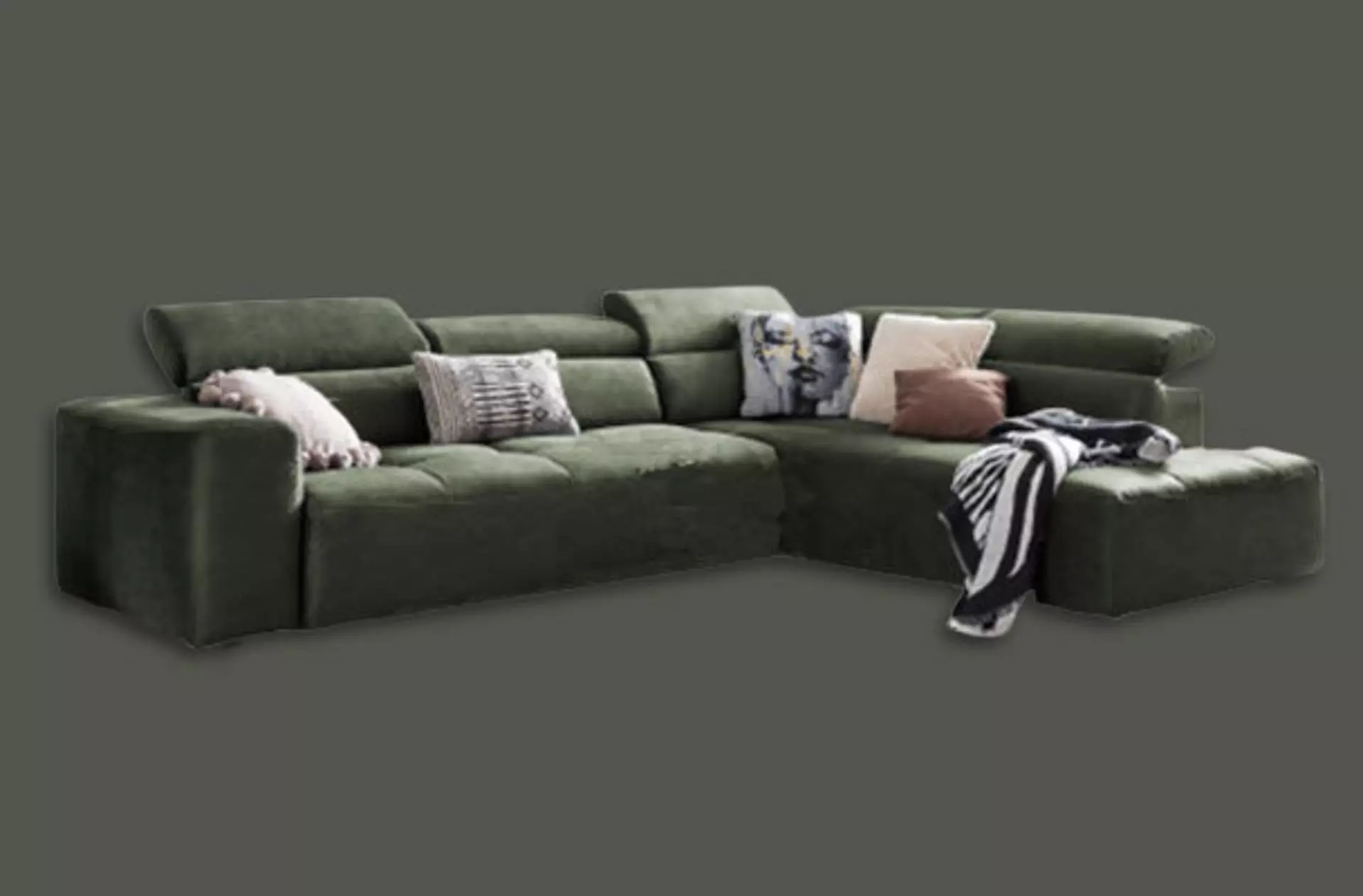 Grünes Sofa mit Kissen und Decken