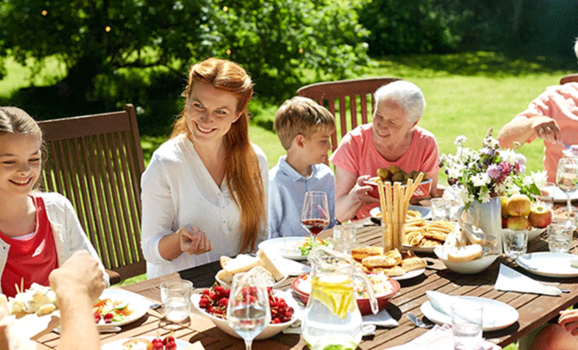 Glückliche Familie beim Essen im Garten