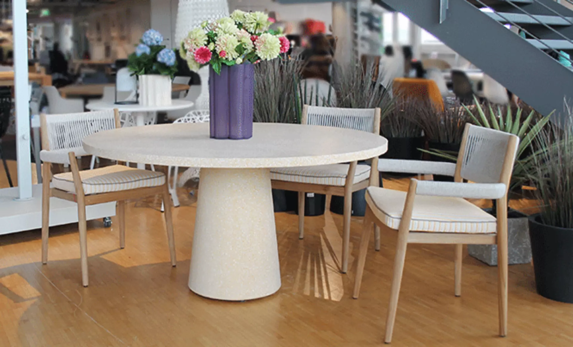 Cassina Outdoor-Tischgruppe in der Ausstellung bei interni by inhofer: der DineOut Tisch in Rund und aus Stein, sowie vier DineOut Stapelstühle