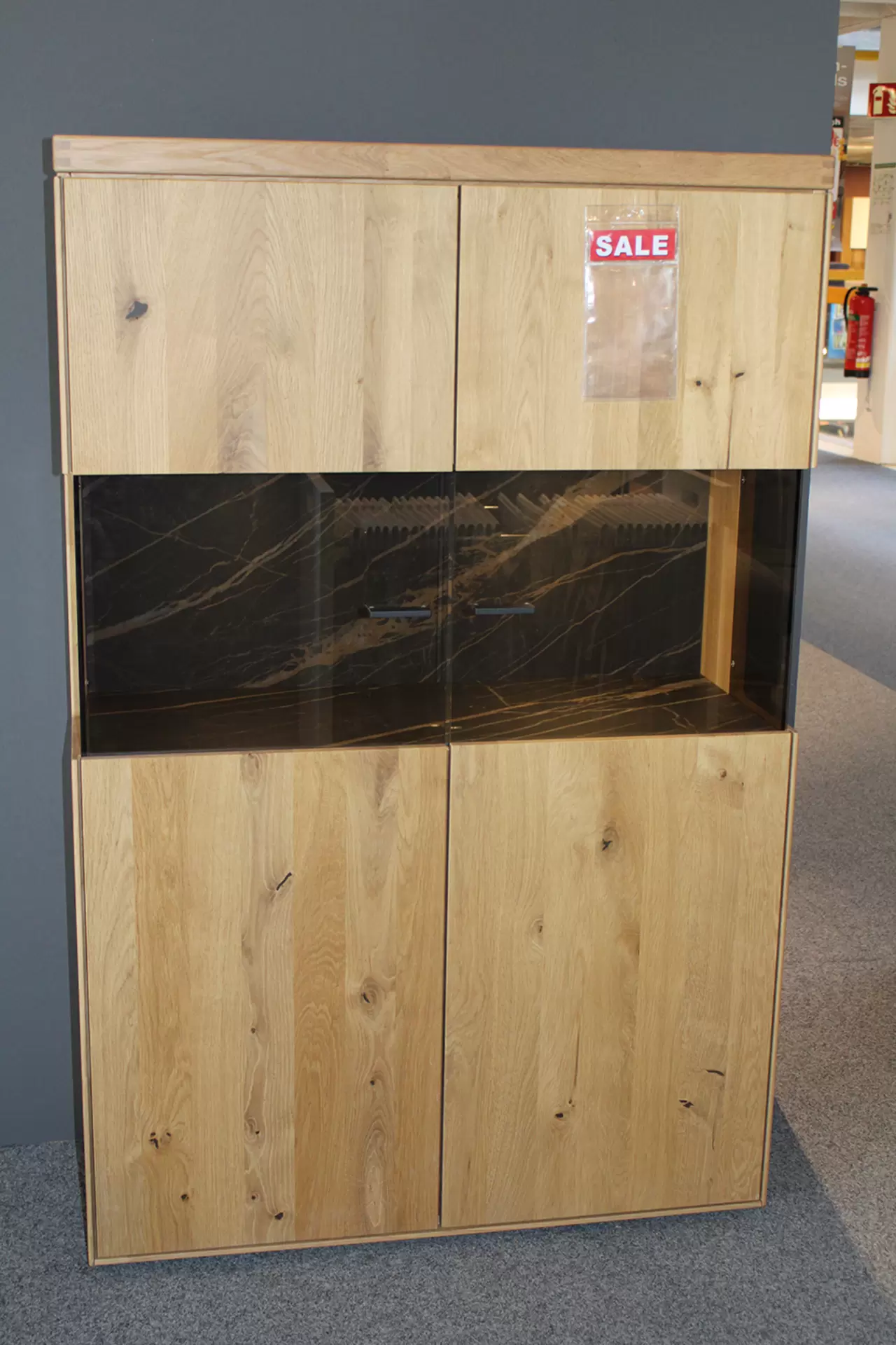 Das Highboard TIRANO von Wöstmann aus massivem Holz miz Glaselementen