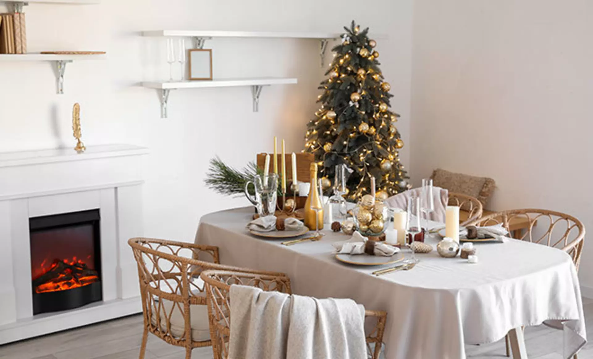 Ein weihnachtlich geschmückter Tisch mit einem geschmückten Weihnachtsbaum und einem Kamin im Hintergrund