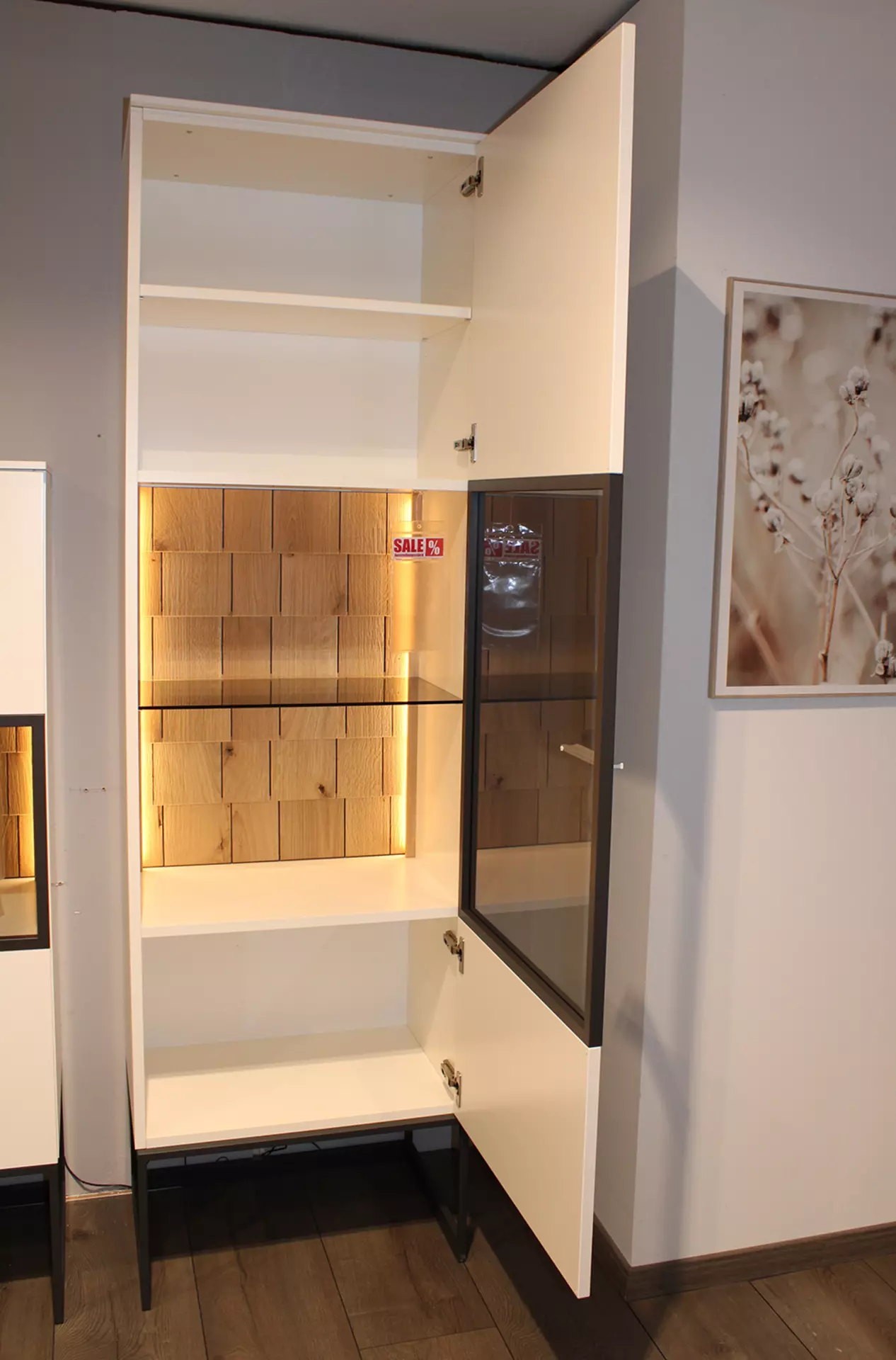 Weiße vitrine mit geöffneter tür und indirekter warmer beleuchtung