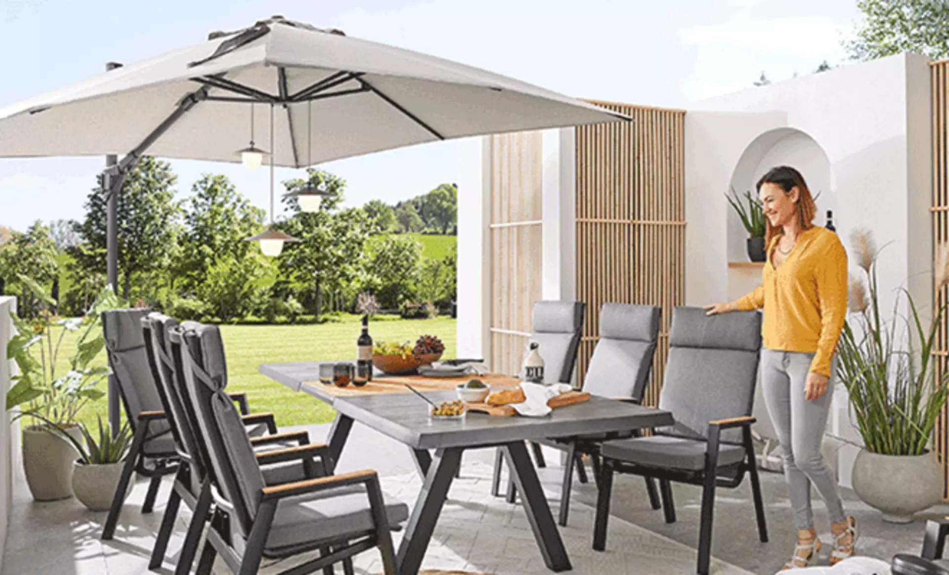 Frau steht vor einem Gartentisch mit Sonnenschutz