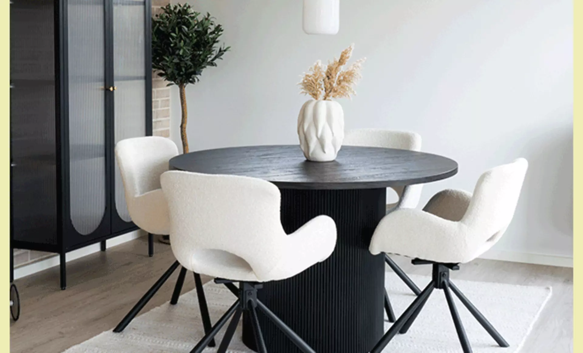 Essbereich mit rundem schwarzen Tisch und modernen weißen Stühlen