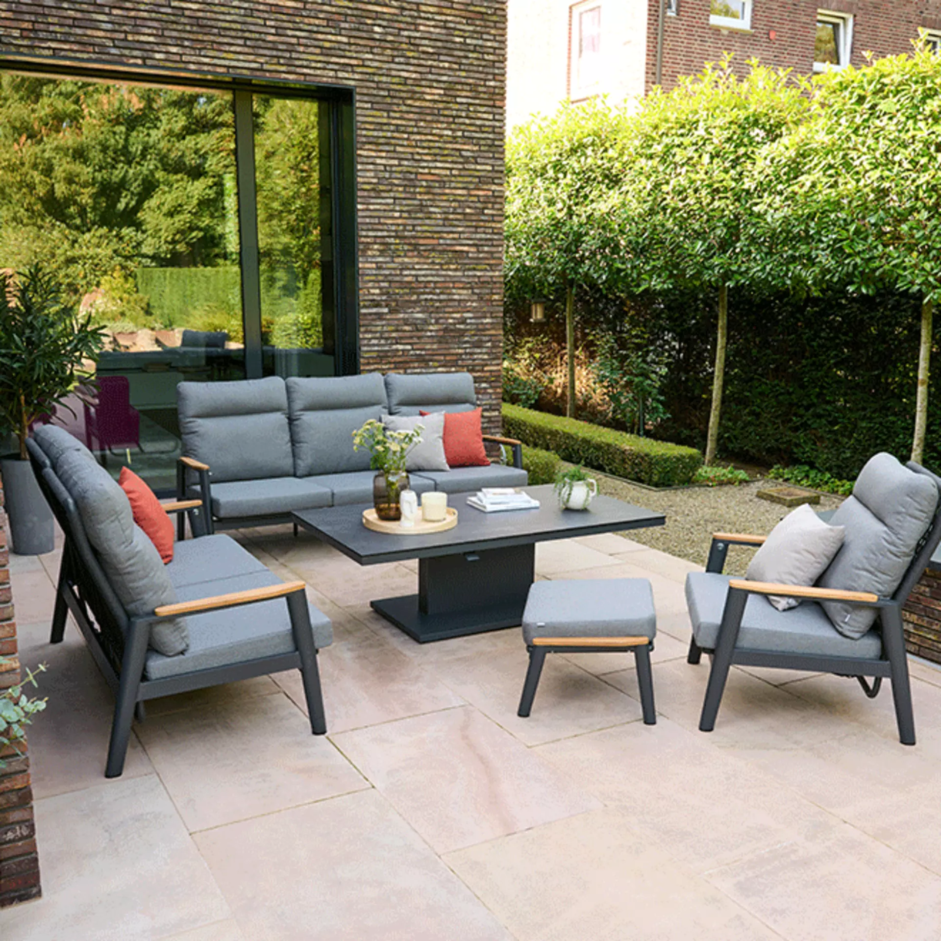 Sitzgruppe mit grauen Möbeln auf gemütlicher Terrasse in einem Garten