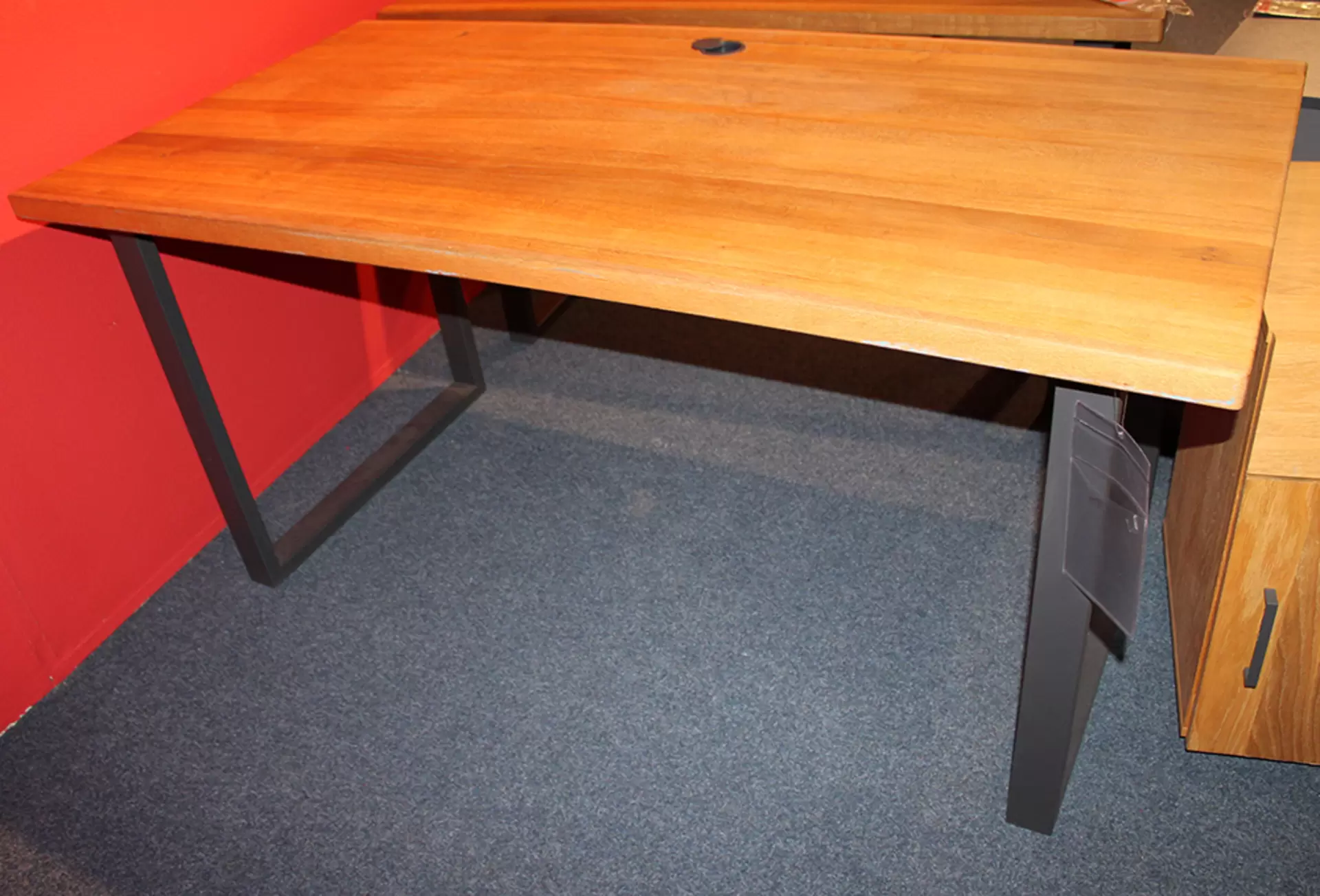Ein Schreibtisch mit massiver Holzplatte und Metallbeinen von CELECT