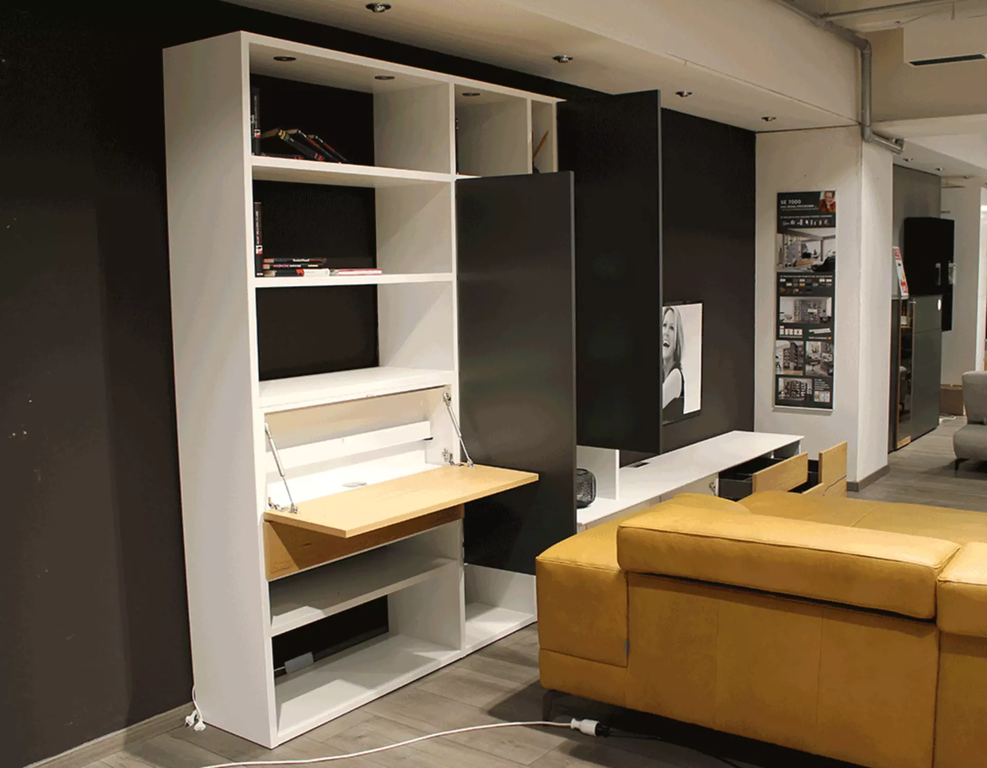 Eine Weiße Wohnwand ausgestatet mit Schubladen und Regalen deren Türen Offen sind 