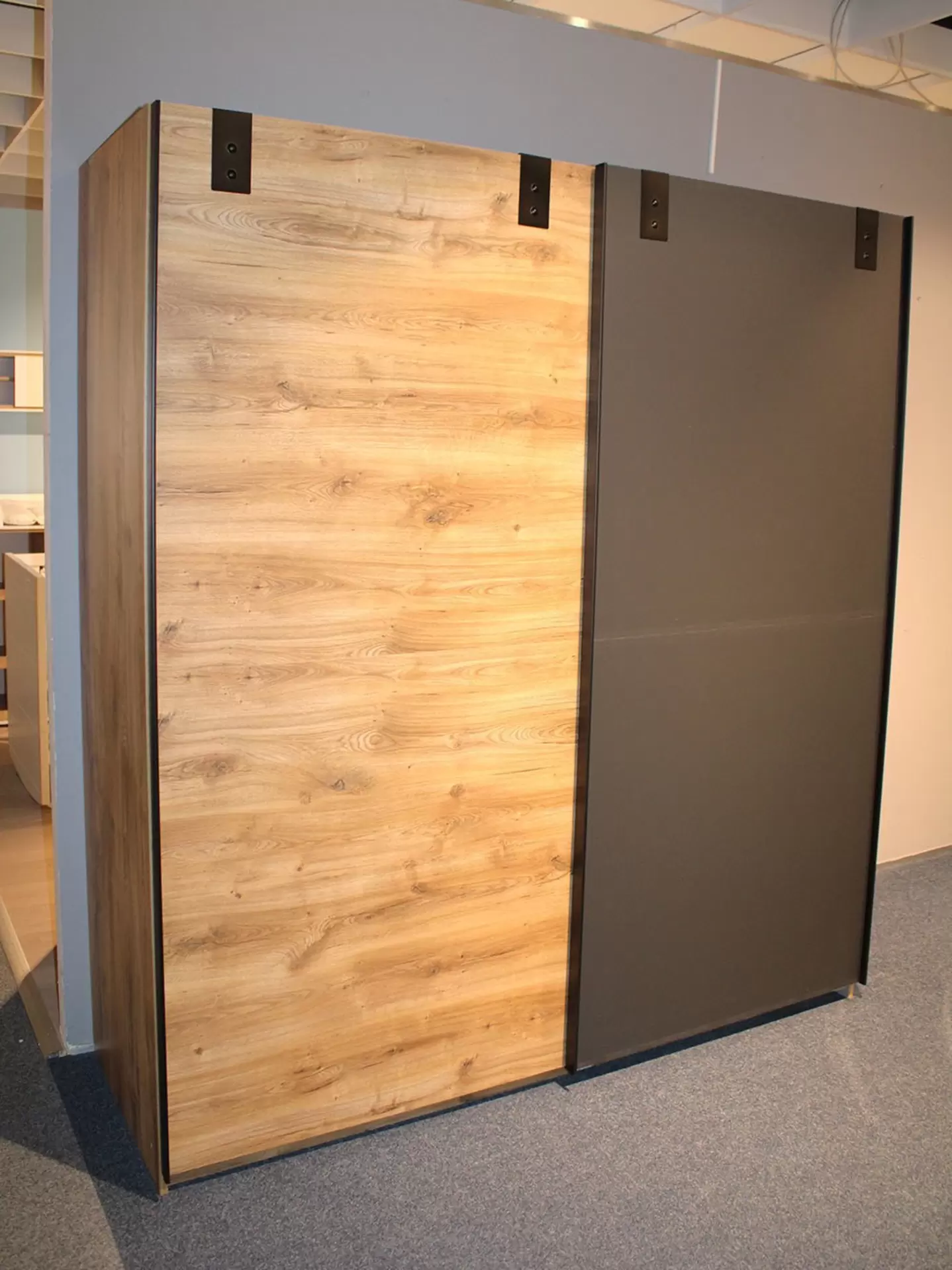 Schwebetürenschrank in schwarz und Holzfarbe