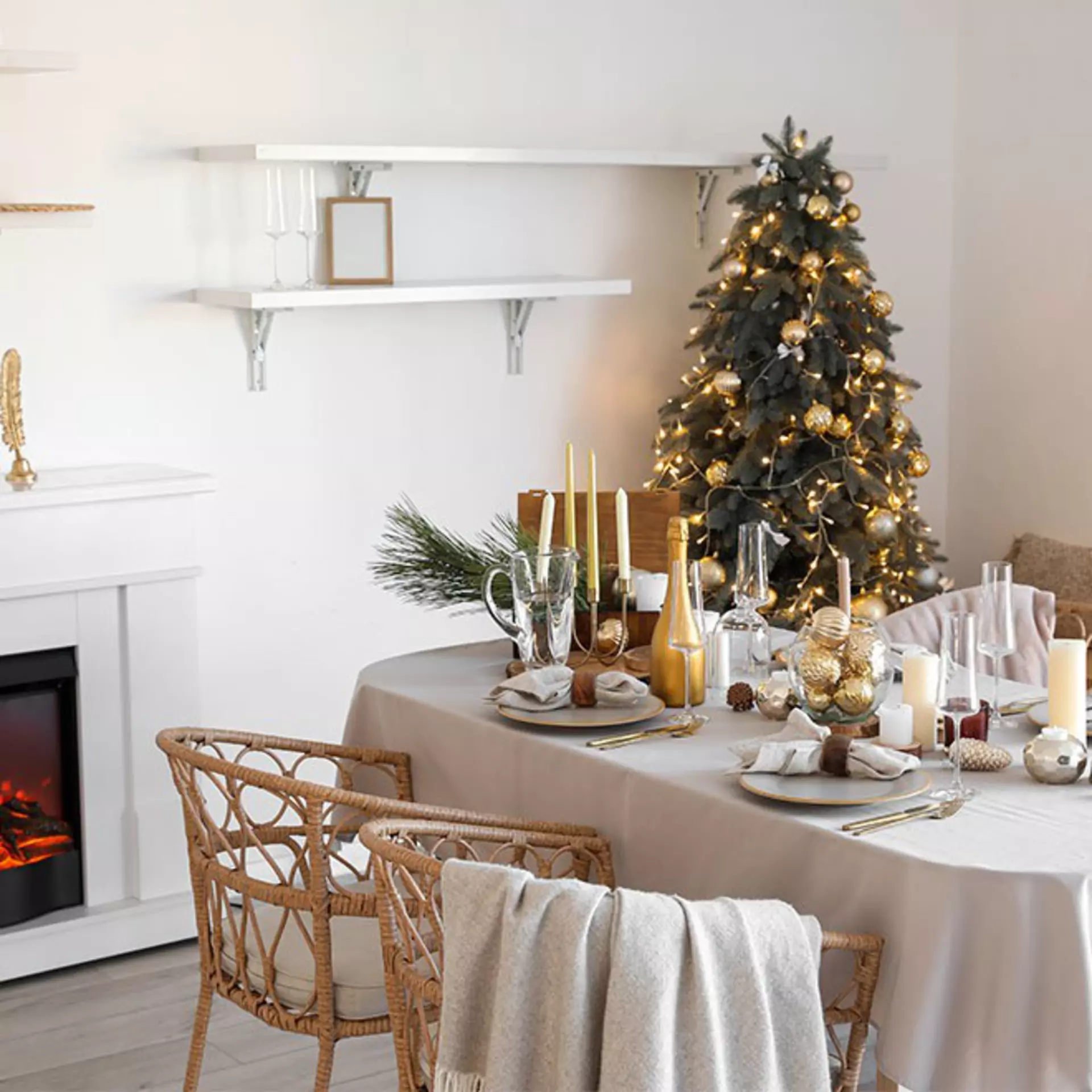 Ein weihnachtlich geschmückter Tisch mit einem geschmückten Weihnachtsbaum und einem Kamin im Hintergrund