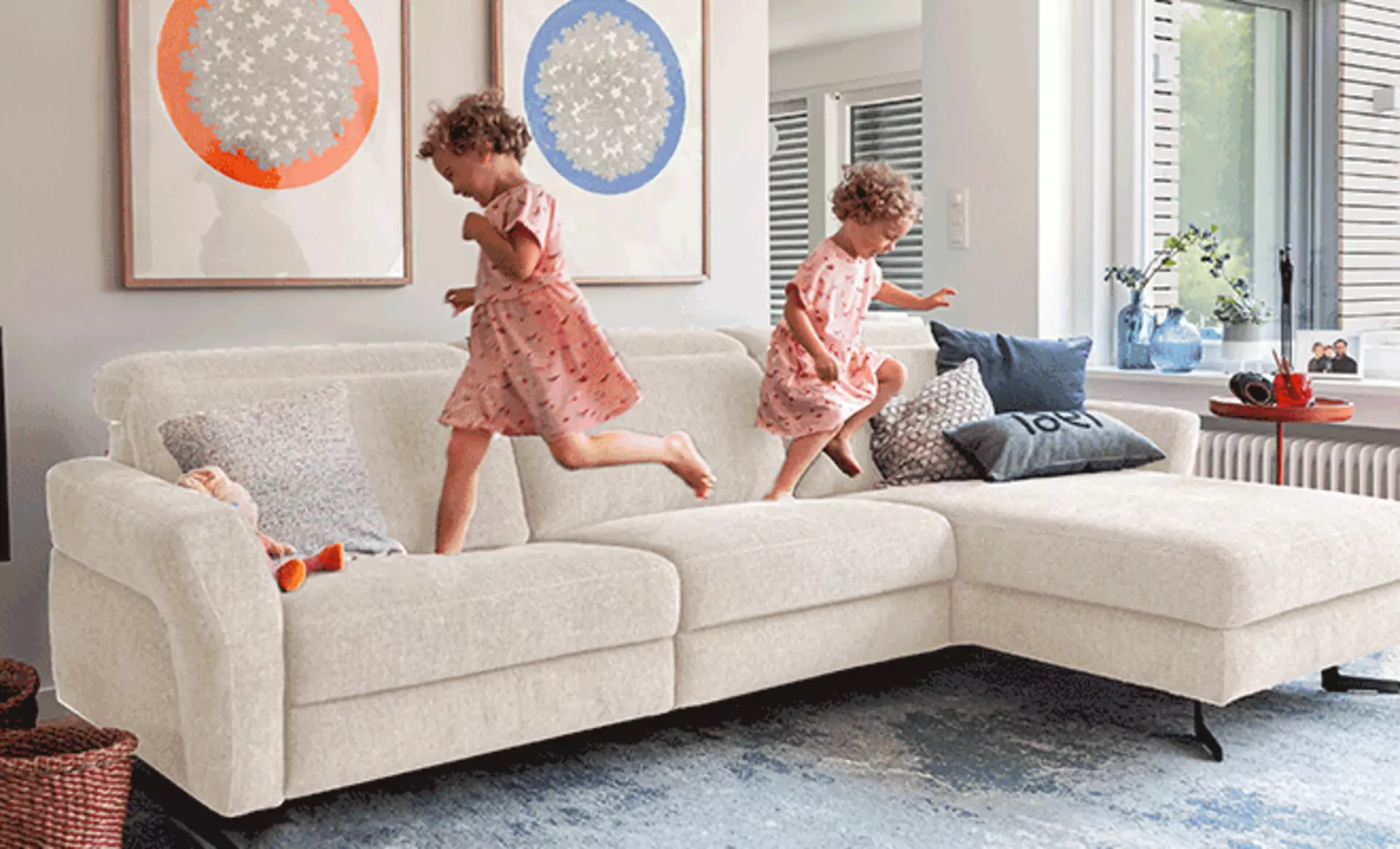 Weißer Ecksofa auf dem kleine Kinder spielen 