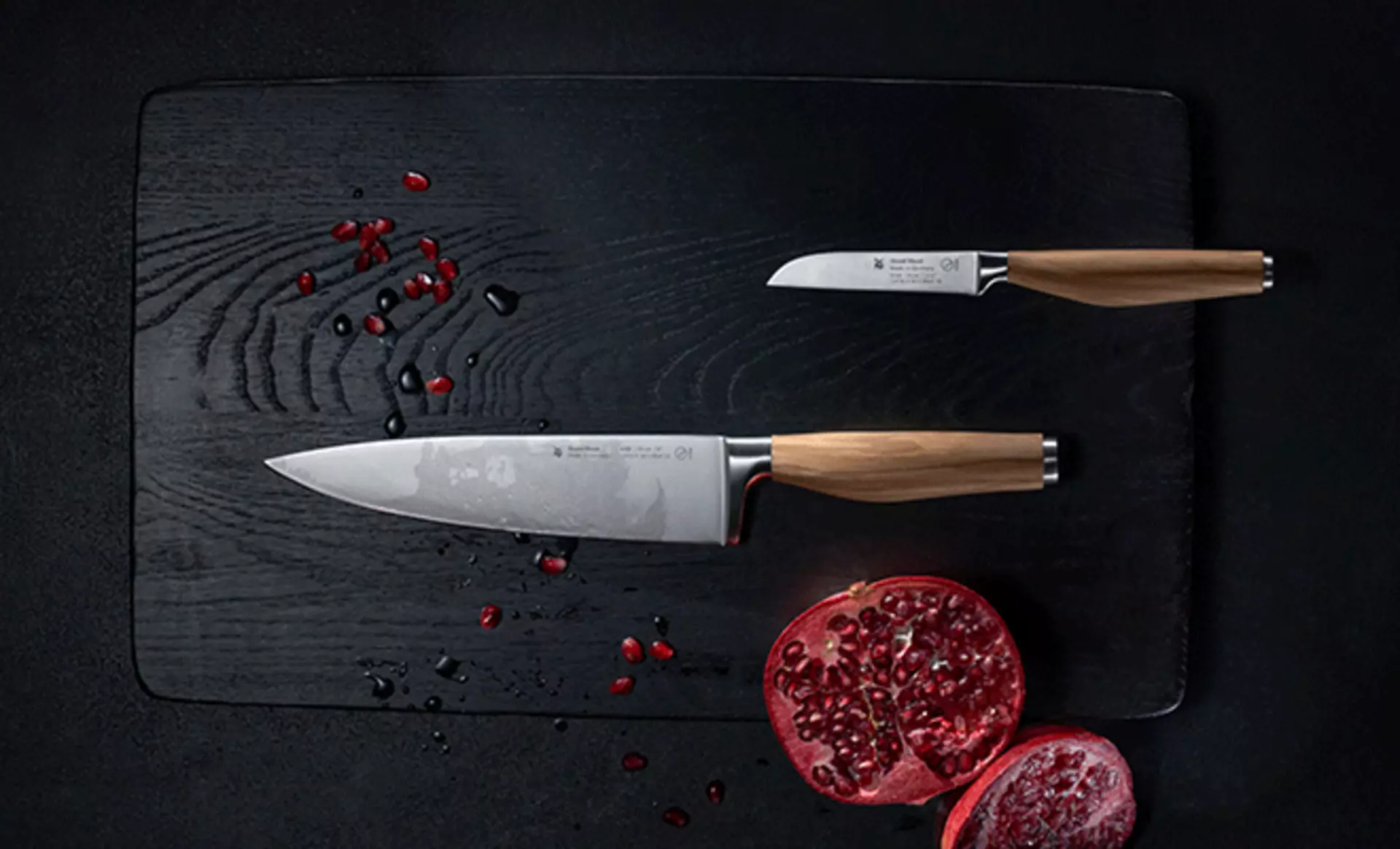 2 Messer in verschiedenen Größen auf einem Schneidebrett