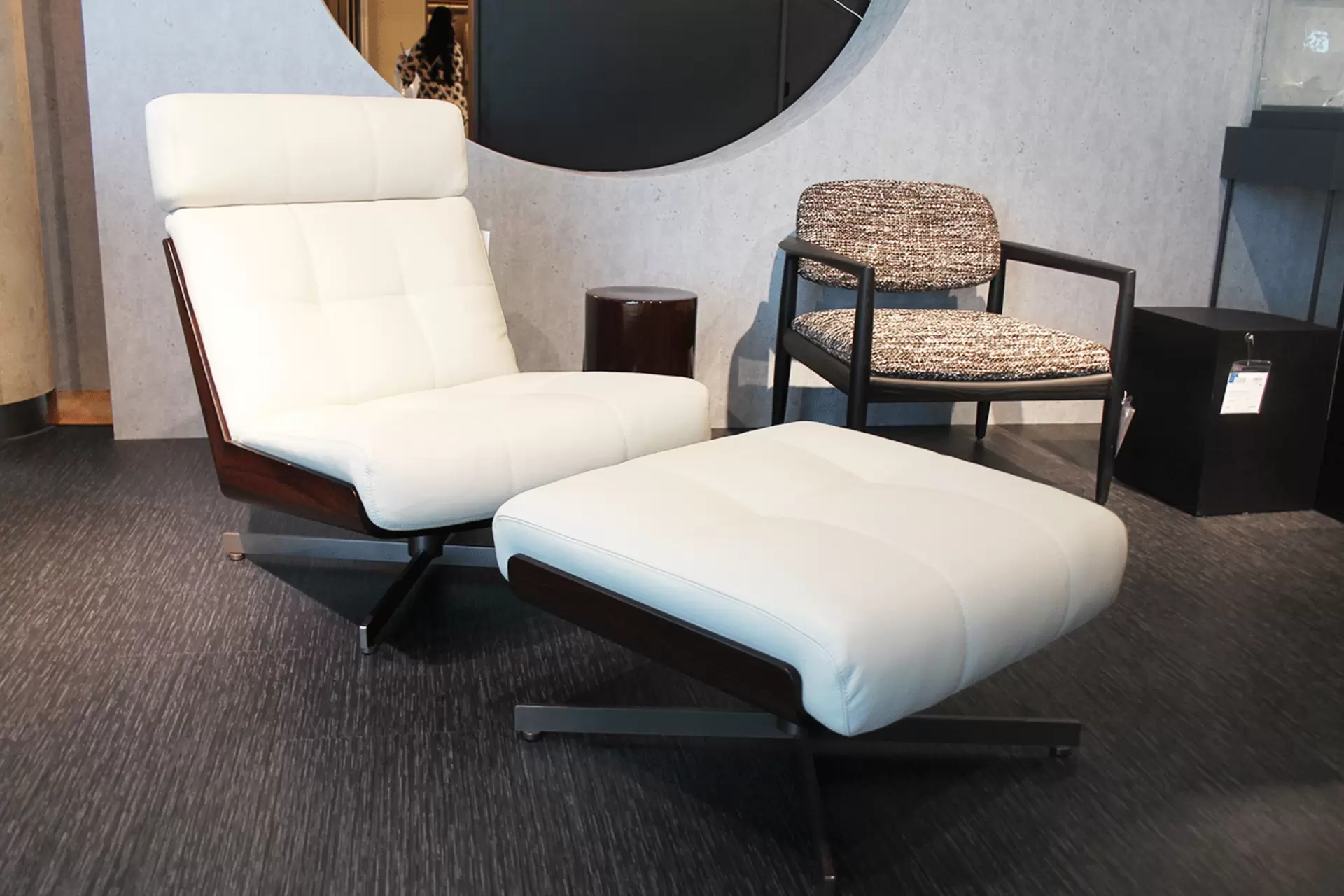 Der Daiki Sessel mit Hocker von Minotti in hellem Leder und dunklem Santos-Palisander