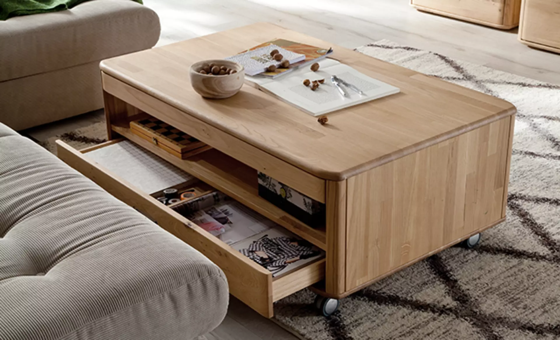 Rollbarer Wohnzimmertisch mit Schubladen und offenen Fächern aus massivem Holz