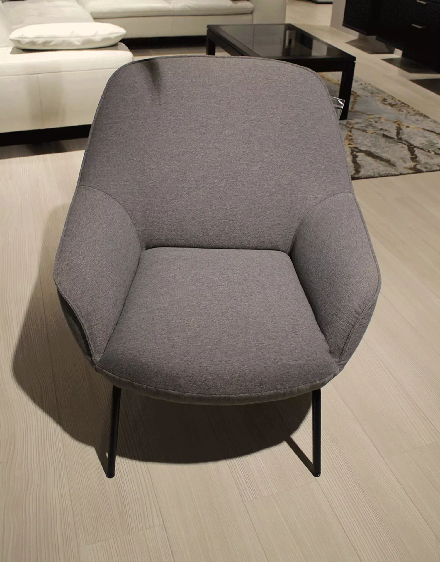 Ein Blau Grauer Sessel das mit Stahlfüßen Ausgestattet ist 