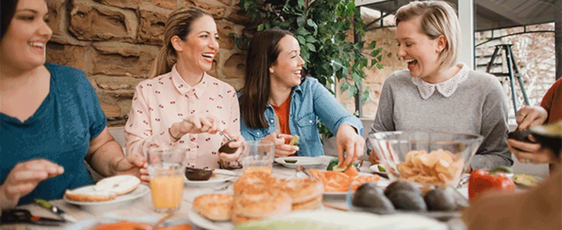 Vier Freunde sitzen zusammen an einem Tisch und essen