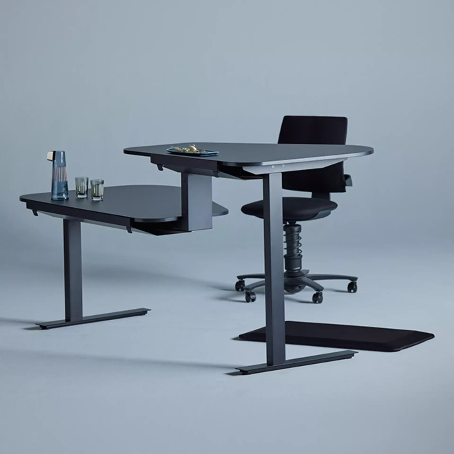 Der duo-Steh und Sitztisch active office Desk von aeris in grauem Furnier vor Studioleinwand