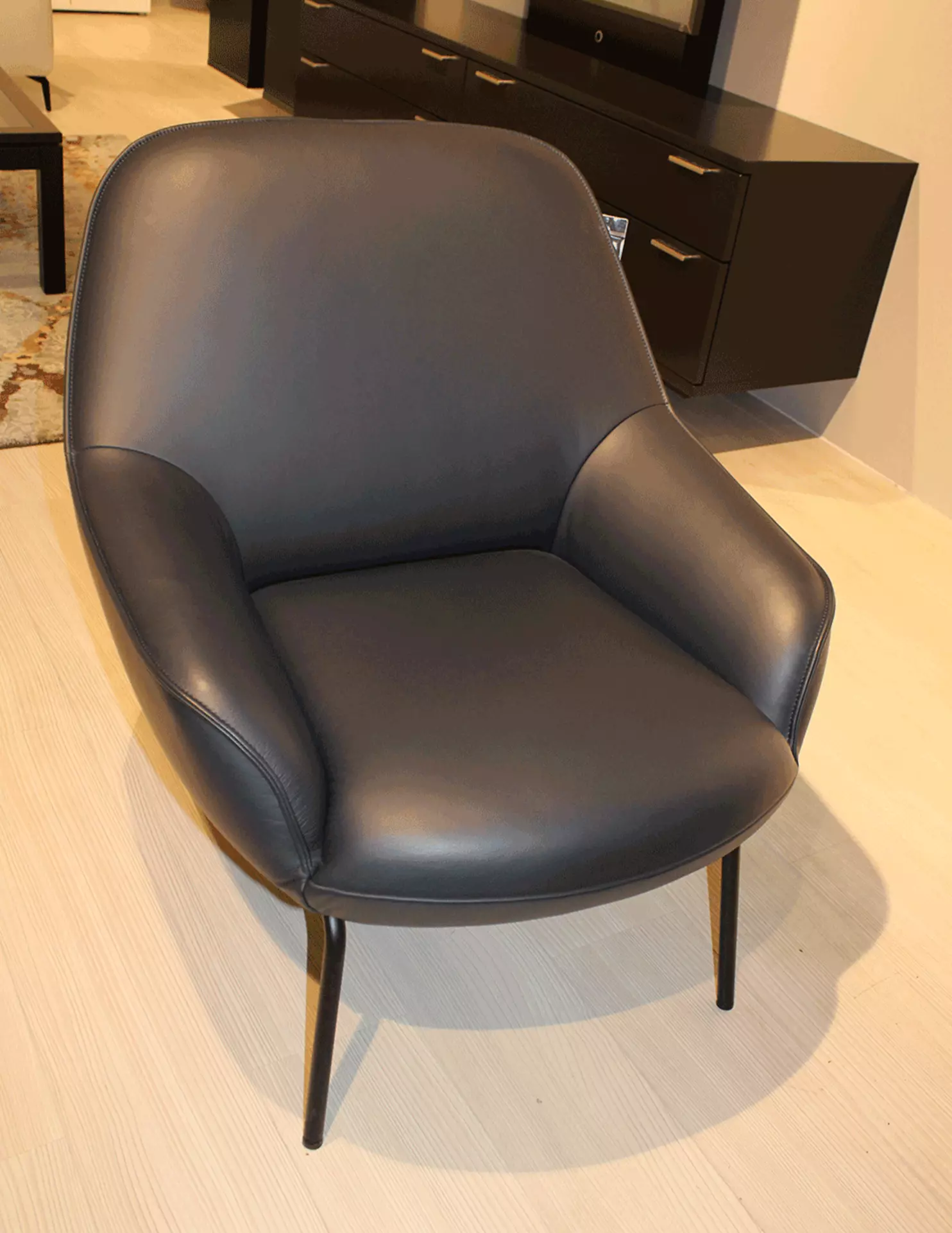 Ein Schwarzer Abgerundeter Sessel mit vier schwarzen Füßen aus Stahl