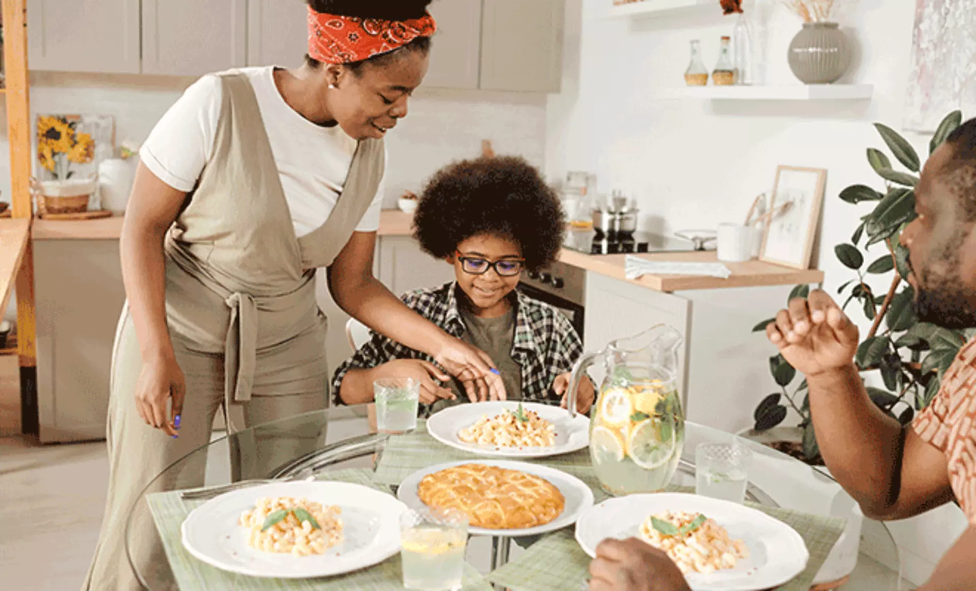 Kleine Familie beim Essen am runden Tisch im Esszimmer.