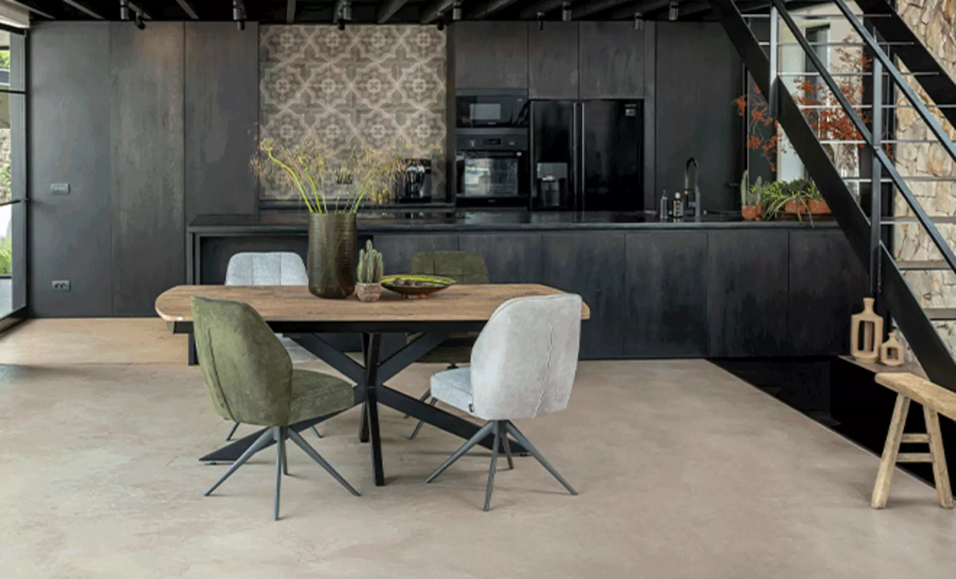 Helle und dunklere Polsterstühle vor dunkler Wohnküche