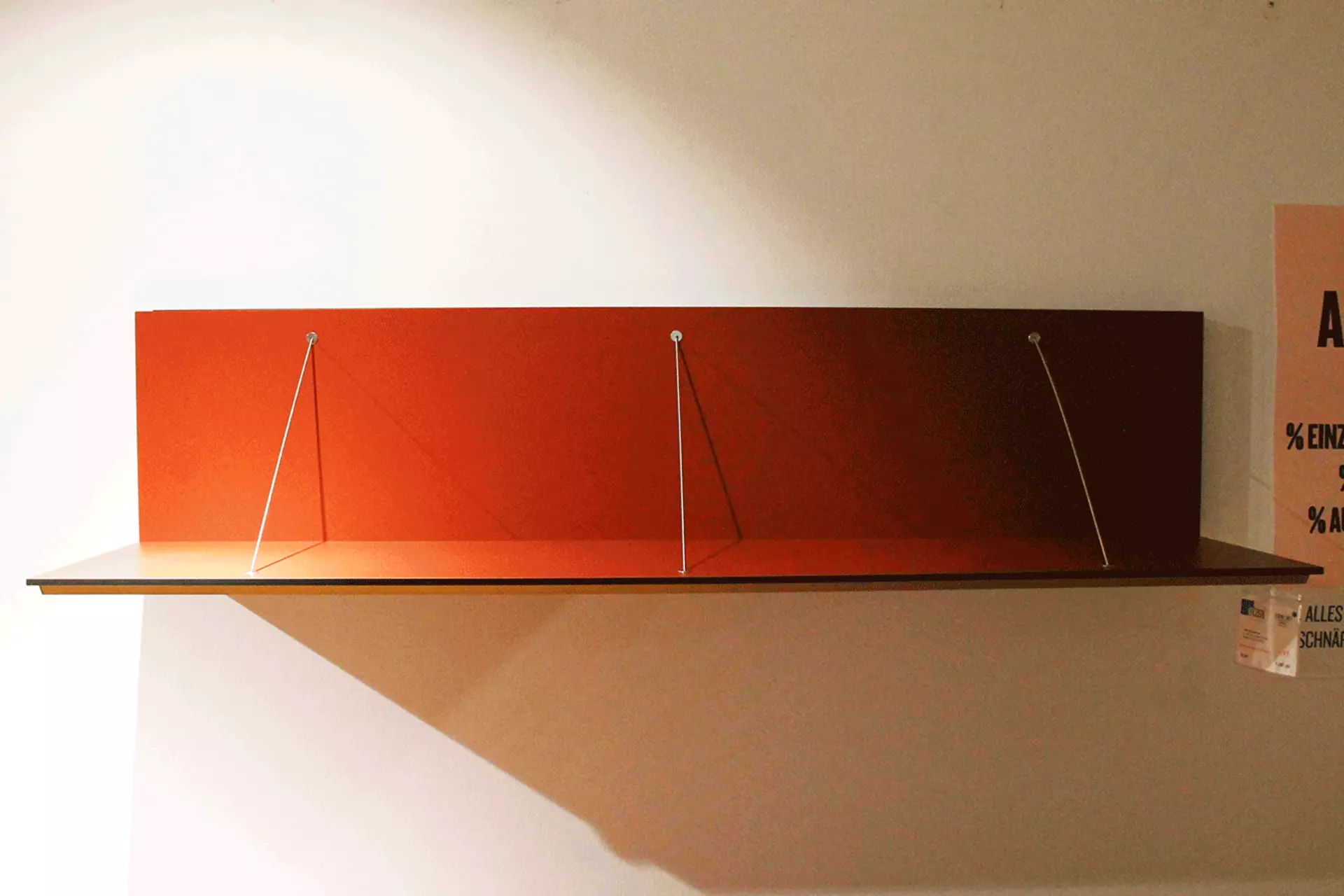 Der Regalboden PAB von B&B Italia in auffälligem Rot an der Wand montiert