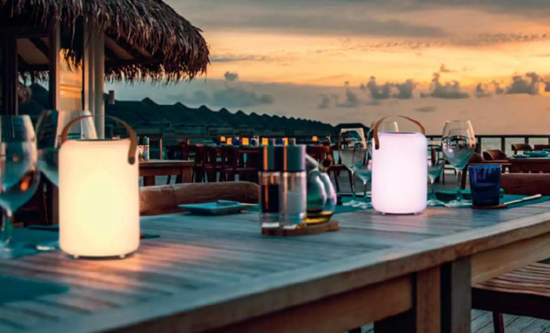 Die Orno Solar Tischleuchten von FH lighting in den Farben beige und Flieder auf einem Sommertisch